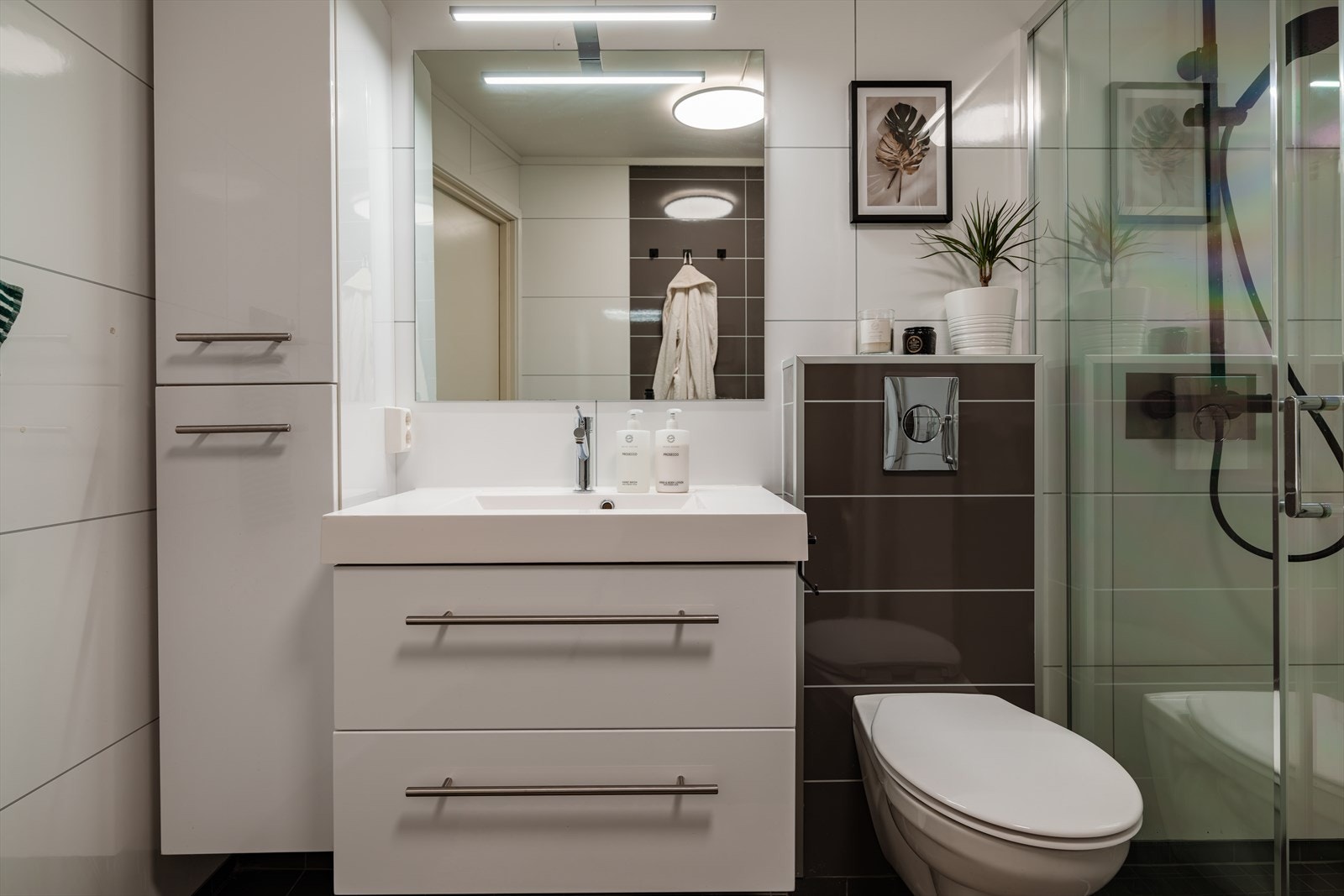 Baderomsinnredningen består av servant med skuffer, vegghengt toalett og speil med belysning. Galleribilde