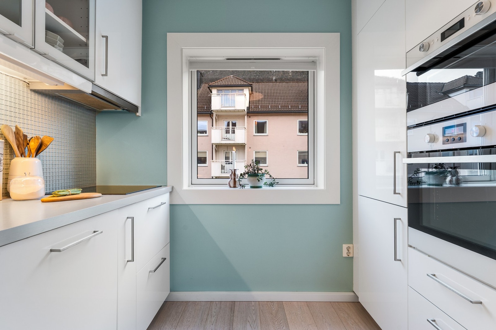 - Kjøkkenet er lyst og pent, med slette fronter og fliser over benkeplate - Galleribilde