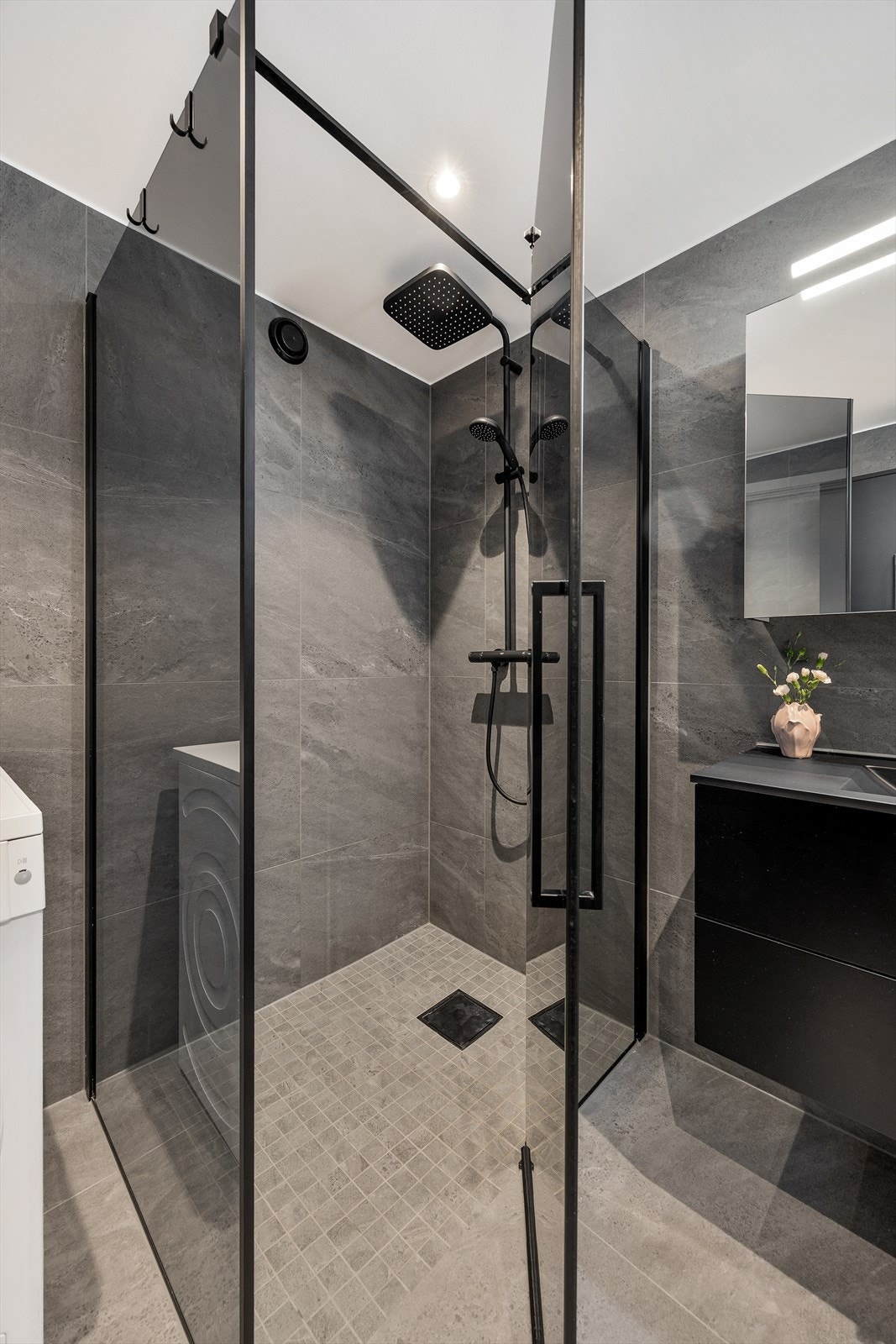 Dusjhjørne med innfellbare glassdører og sluk i gulvet. Galleribilde