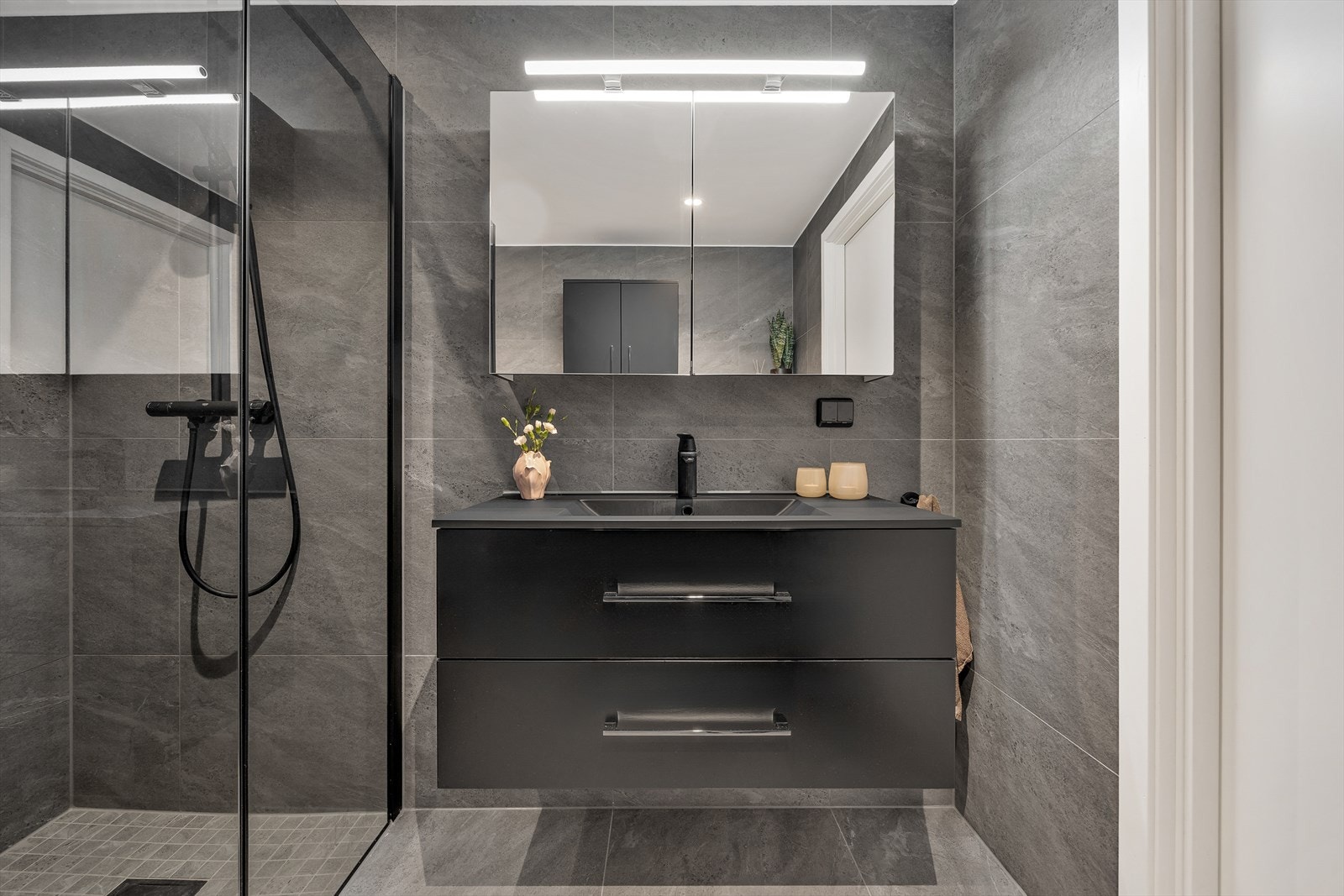Baderomsinnredning med heldekkende servant, og speilskap med integrert belysning. Galleribilde