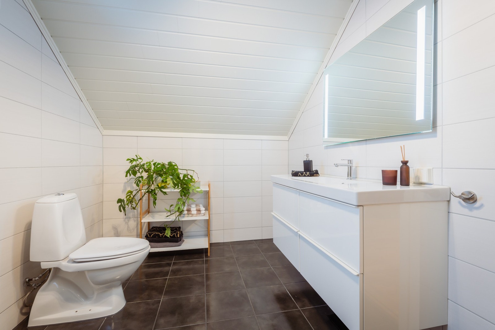 Badet er innredet med toalett, servant med skuffer og dusjkabinett. Varme i gulvet. Galleribilde