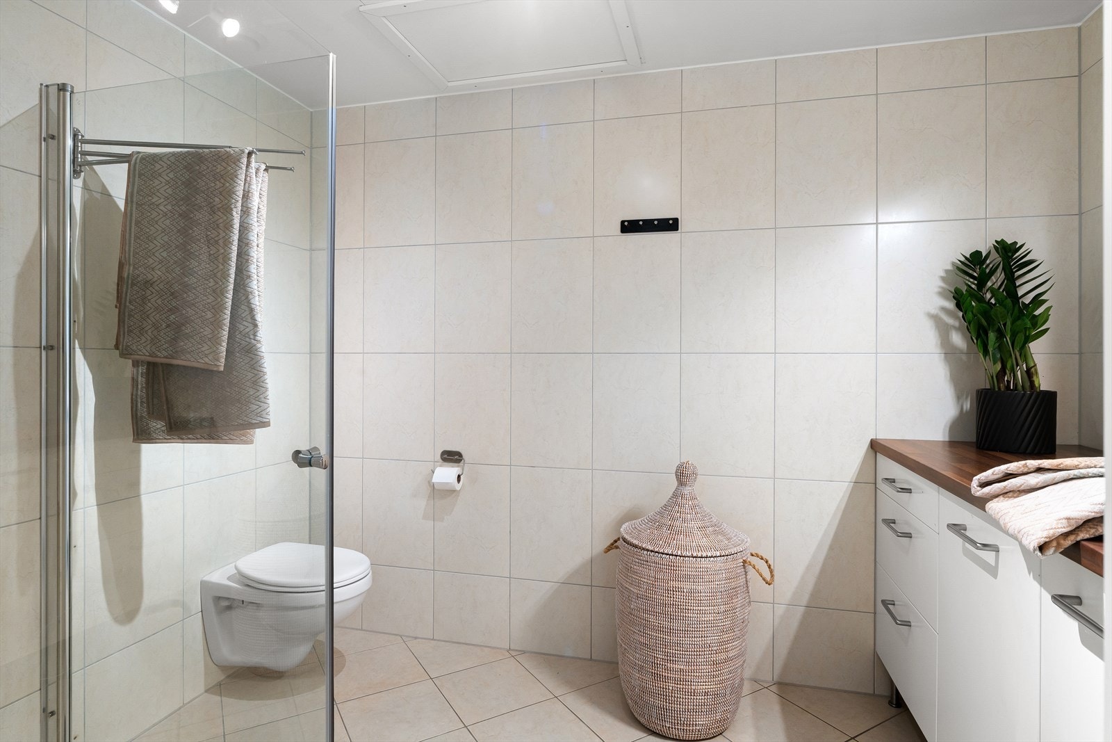 Bad med lyse fliser på gulv og vegg Galleribilde