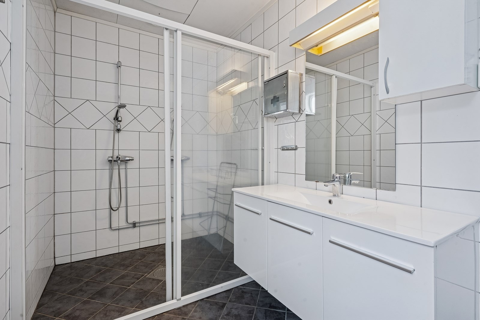 Badet er utstyrt med servant i innredning og et romslig dusjkabinett. Galleribilde