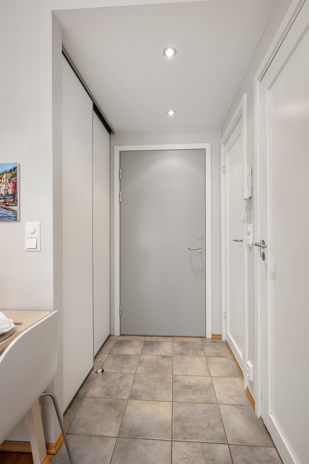 Entréen har flislagt gulv og skyvedørsgarderobe. Galleribilde