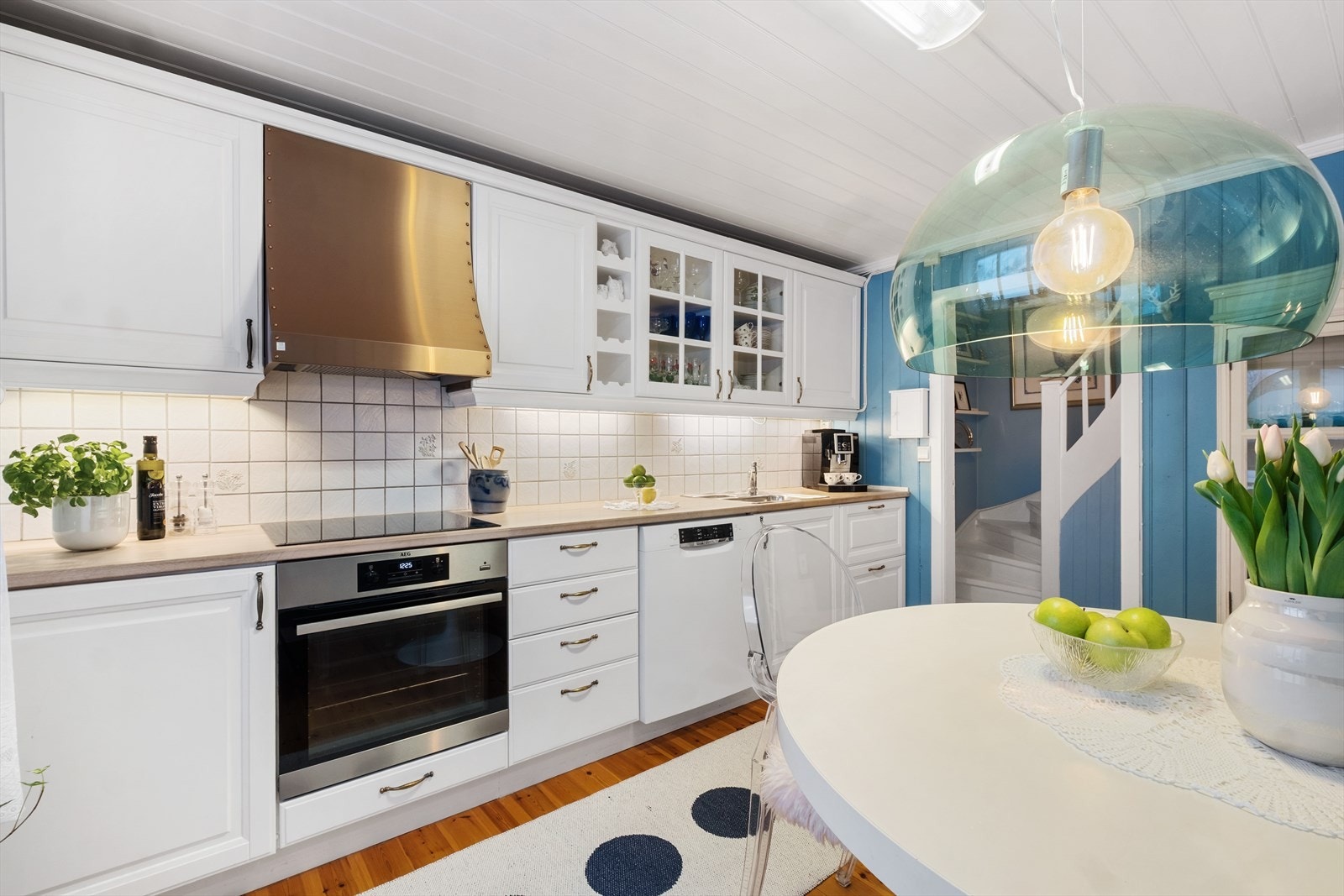 Kjøkken med hvite profilerte fronter og benkeplate med nedfelt servant. Galleribilde