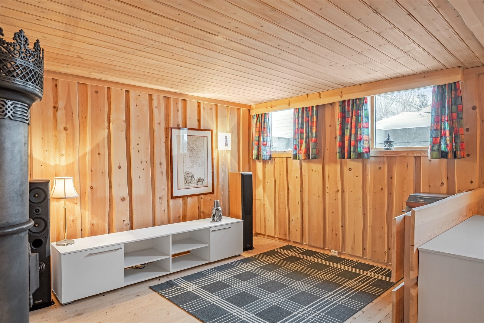 Kjellerstuen har panel på vegger og laminat på gulv. Galleribilde