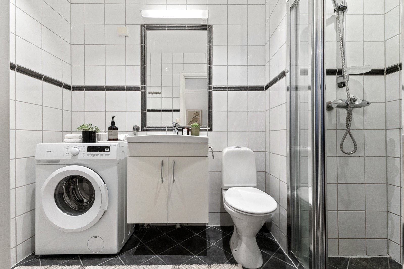 Badet fremstår tidløst og funksjonelt, med flislagte overflater og gjennomtenkte løsninger. Galleribilde