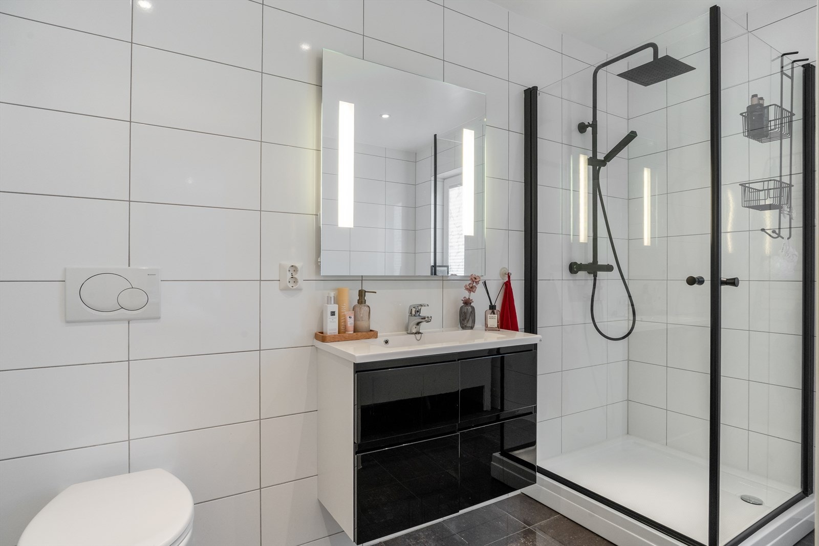 Baderom i 1. etasje med dusj, baderomsmøbel med servant samt vegghengt toalett. Galleribilde