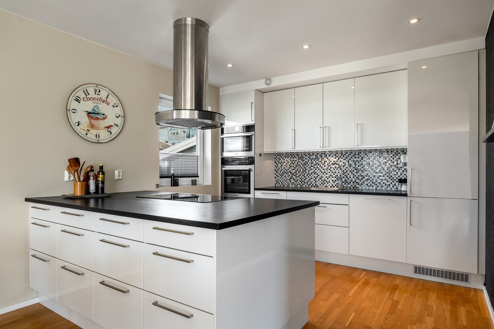 Pent kjøkken med hvite, slette fronter. God skap- og benkplass. Integrerte hvitevarer. Galleribilde