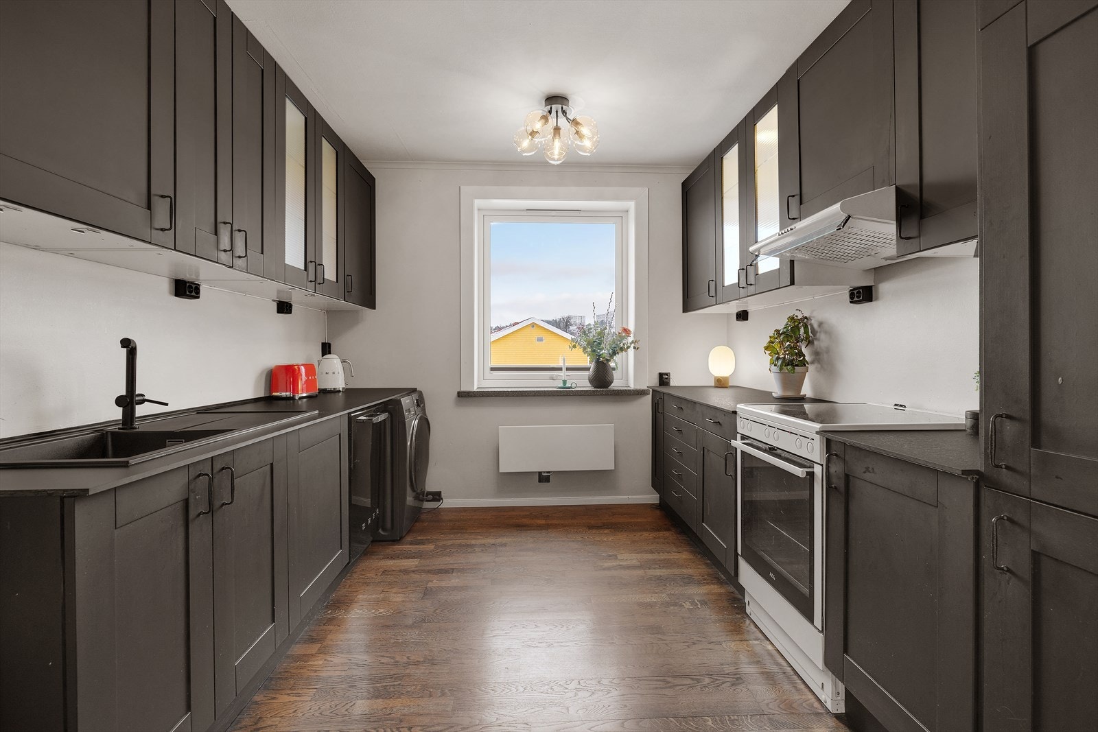 Ikea kjøkkeninnredning med profilerte fronter og glassfronter. Benkeplaten er i kompositt og finer med oppvaskkum og 1-greps blandebatteri. Galleribilde