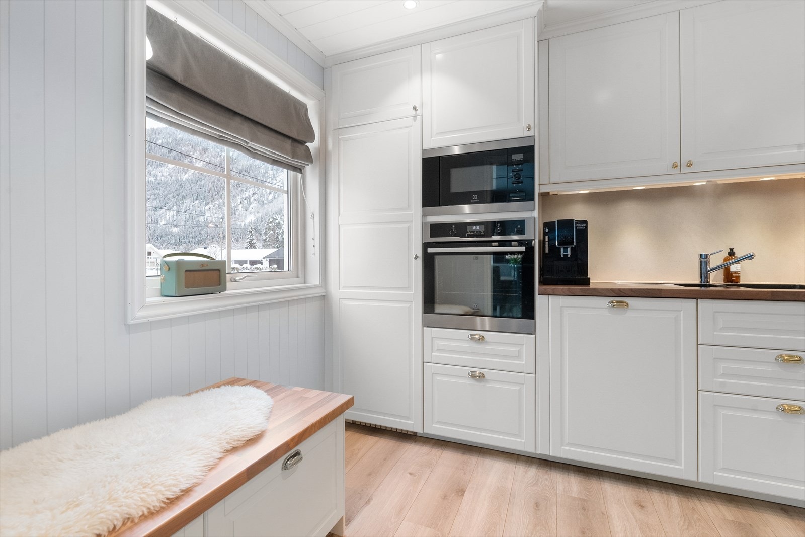 Kjøkkenet har en pen og takhøy innredning fra 2018 med profilerte fronter og noe glasskap, samt benkeplate i laminat. På kjøkkenet er det også en hyggelig sittebenk i samme, pene utførelse som innredningen. Galleribilde