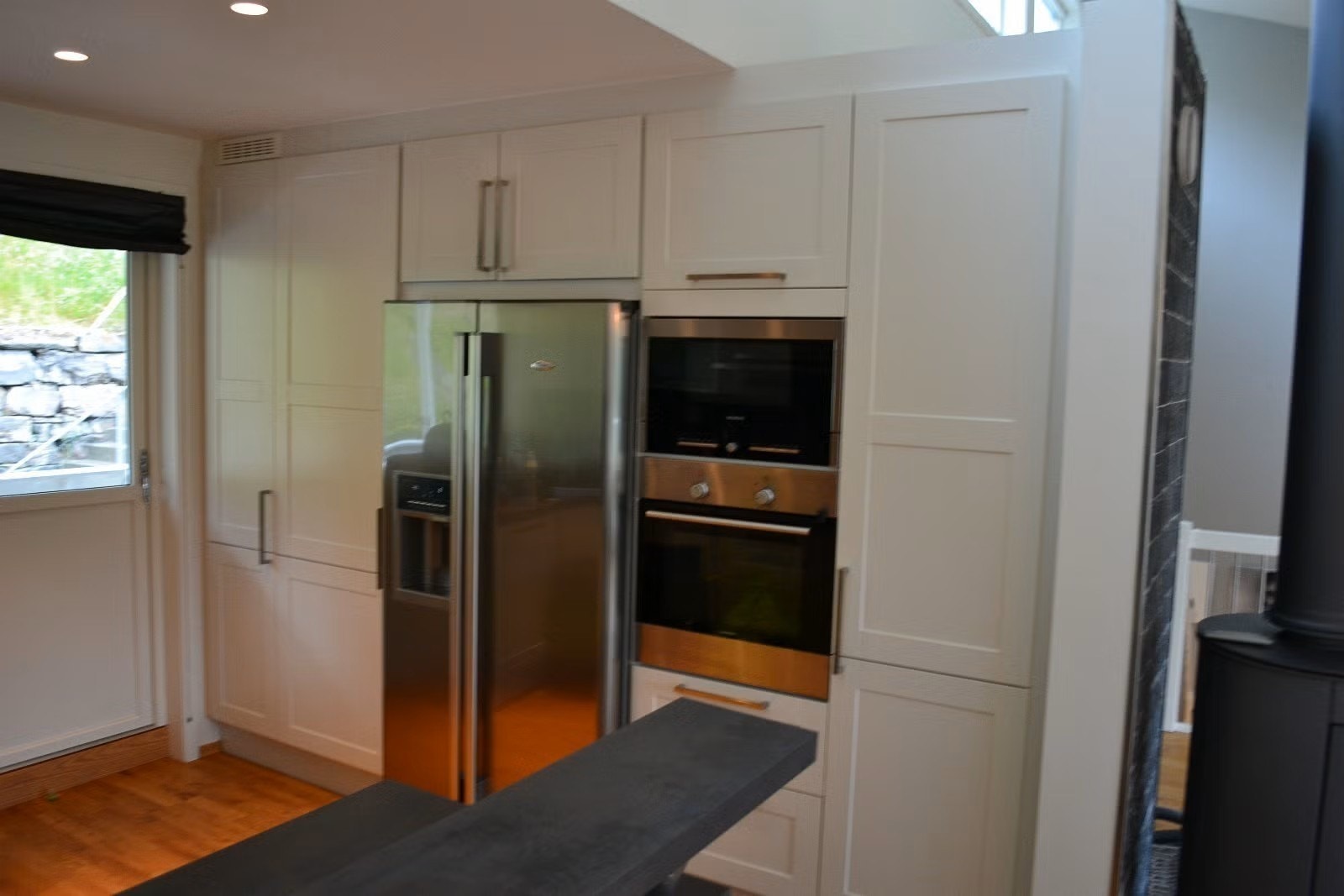 Stilrent kjøkken med integrert mikrobølgeovn, komfyr, kjøleskap og fryseskap. Galleribilde