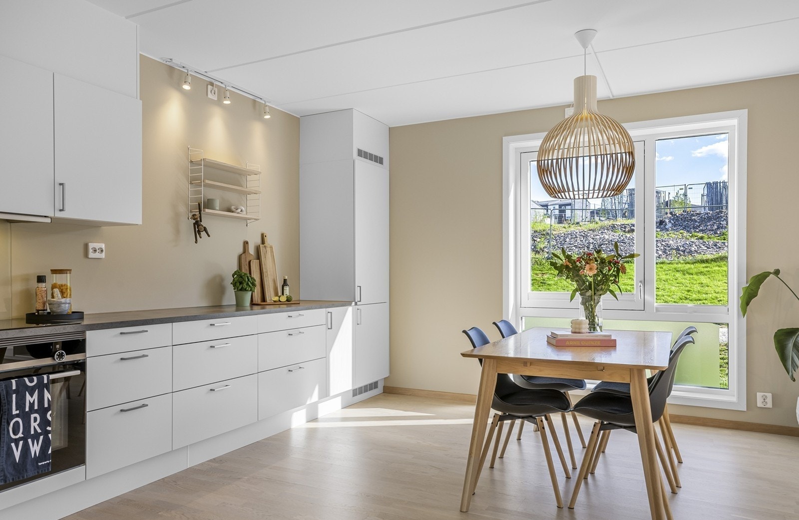 Alle nødvendige hvitevarer er integrert, inkludert platetopp, komfyr, oppvaskmaskin og kombiskap med kjøl/frys - alt gir et helhetlig og stilrent uttrykk. Galleribilde