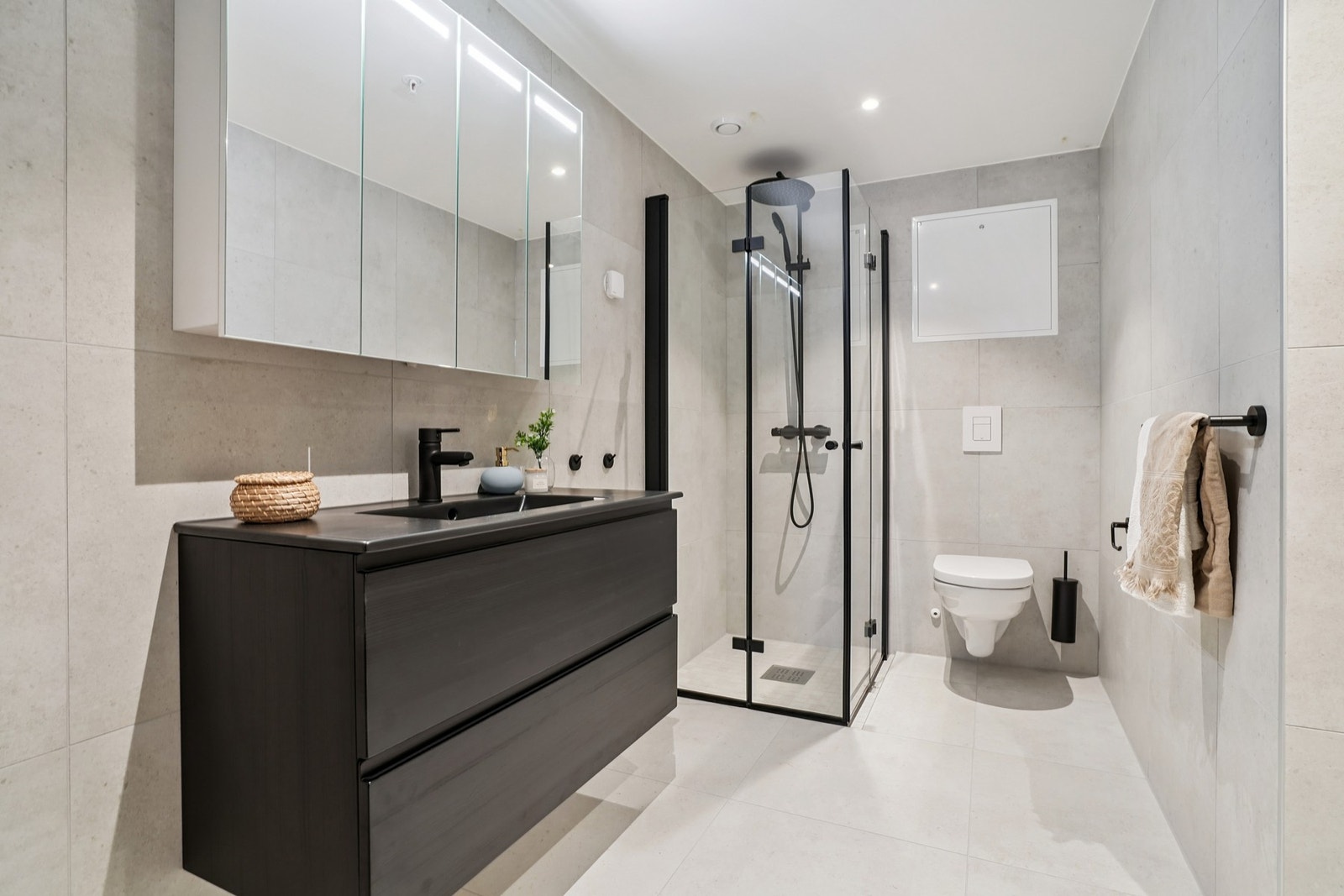 Badet er helfliset i delikate fargetoner og har elektriske varmekabler i gulvet. Rommet kombineres med vaskerom og det er opplegg for vaskemaskin. Galleribilde