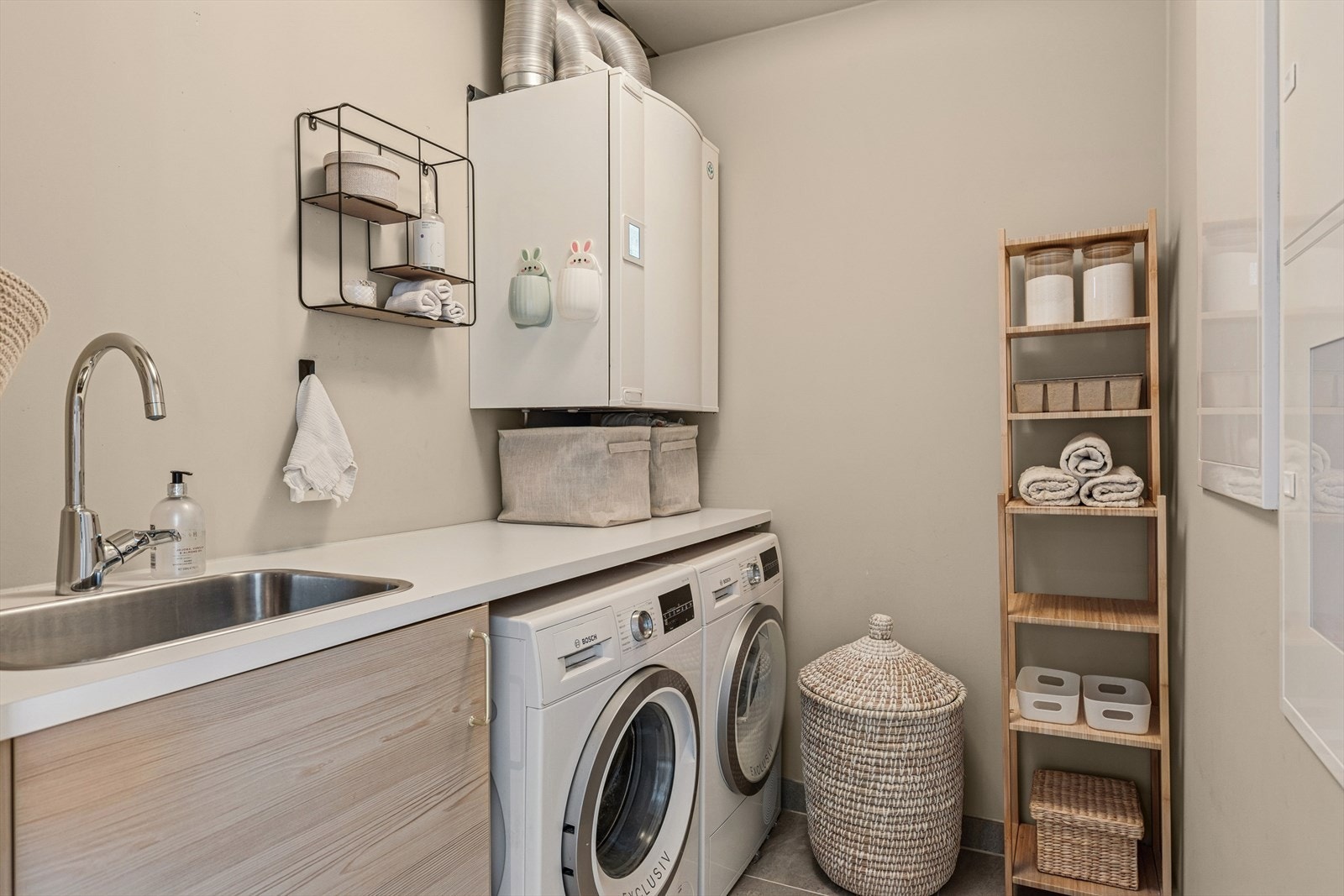 Vaskerommet er utformet for en praktisk og komfortabel hverdag, med flislagt gulv og malte plater på veggene Galleribilde