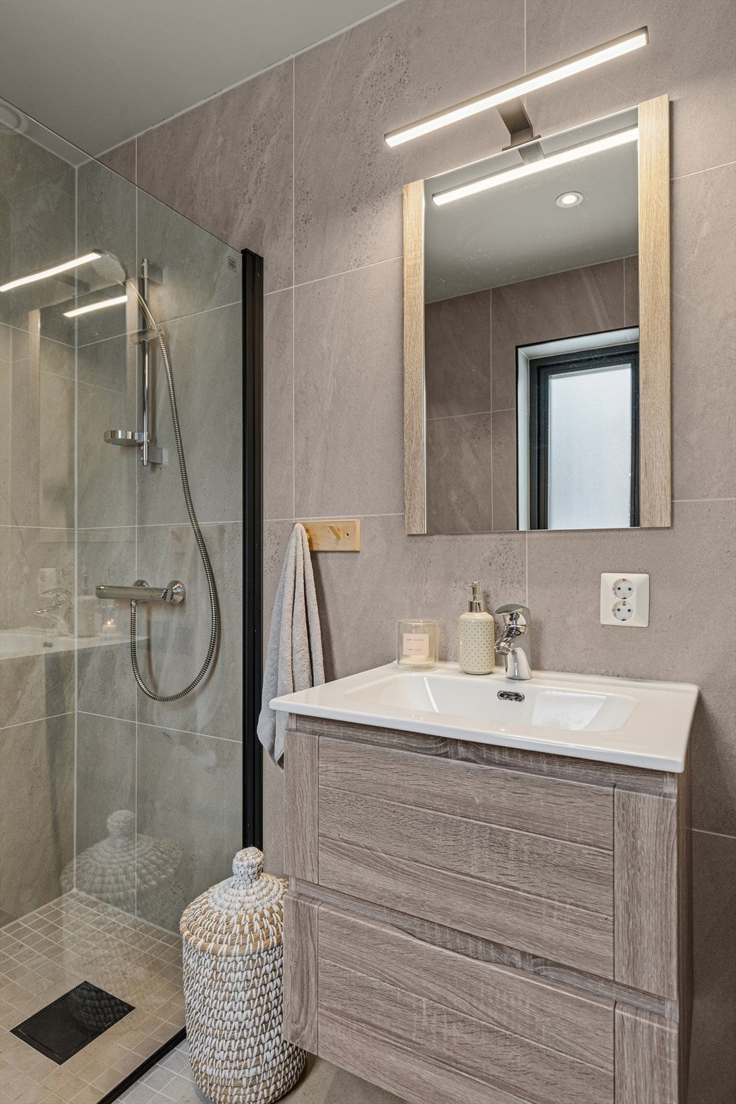 Badet i 1. etasje fungerer utmerket som gjestebad, og er utført i samme moderne stil som hovedbadet Galleribilde