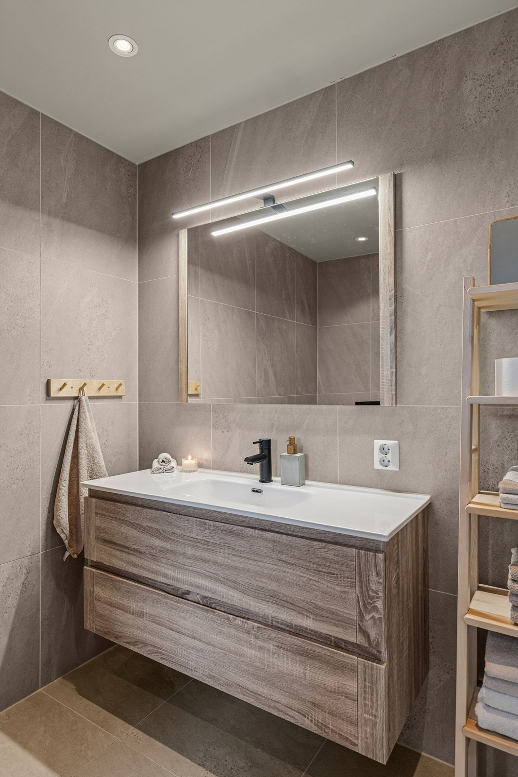 Badet er helfliset med lyse, elegante vegg- og gulvfliser med behagelig gulvvarme. Downlights i himlingen sørger for god og jevn belysning Galleribilde