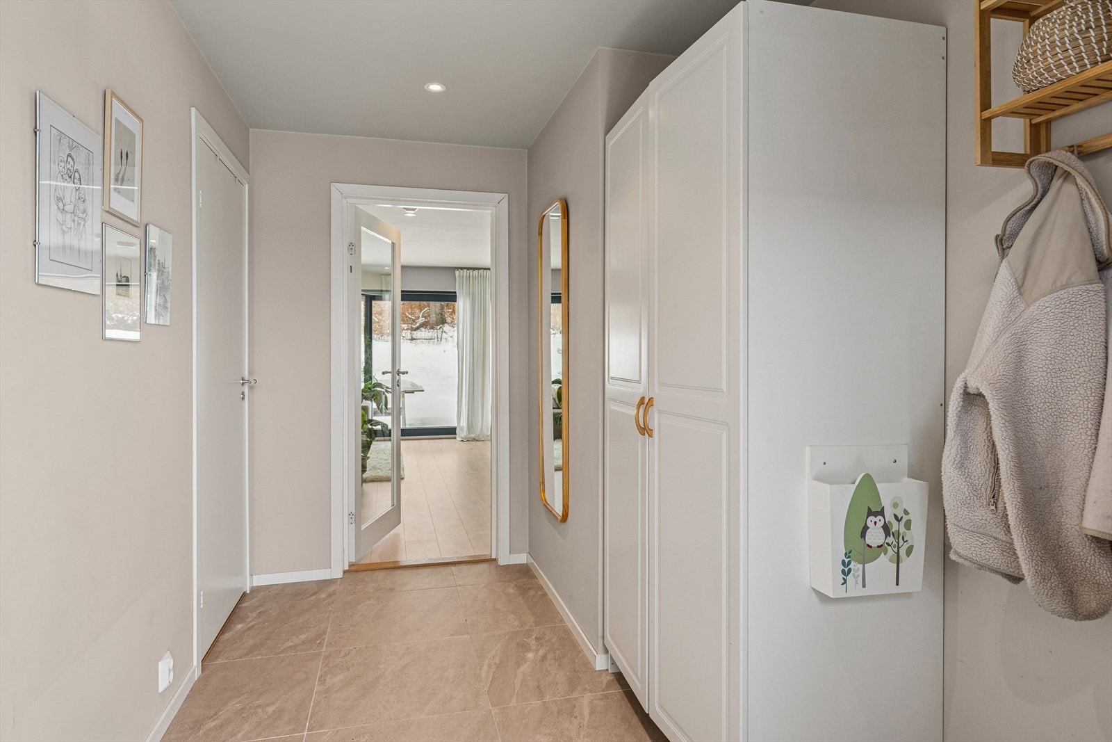 Innenfor døren møtes du av en romslig og lys gang med god plass til både sko og yttertøy i praktiske garderobeskap med profilerte fronter Galleribilde