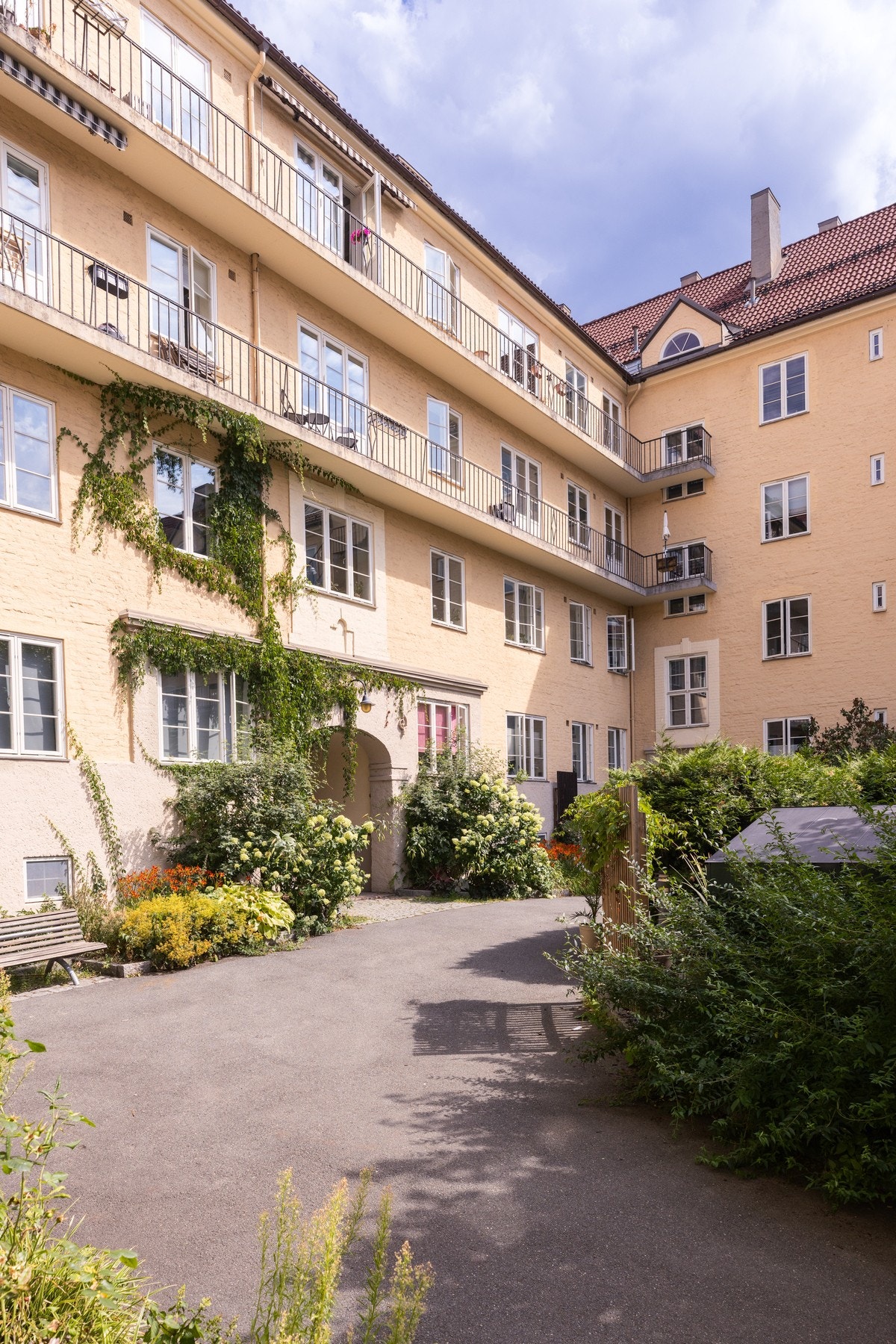 Inngang til gårdsrom via portal. På sommerstid vil du se at borettslaget er vel kjent for sine fantastiske blomster som omkranser borettslaget! Galleribilde