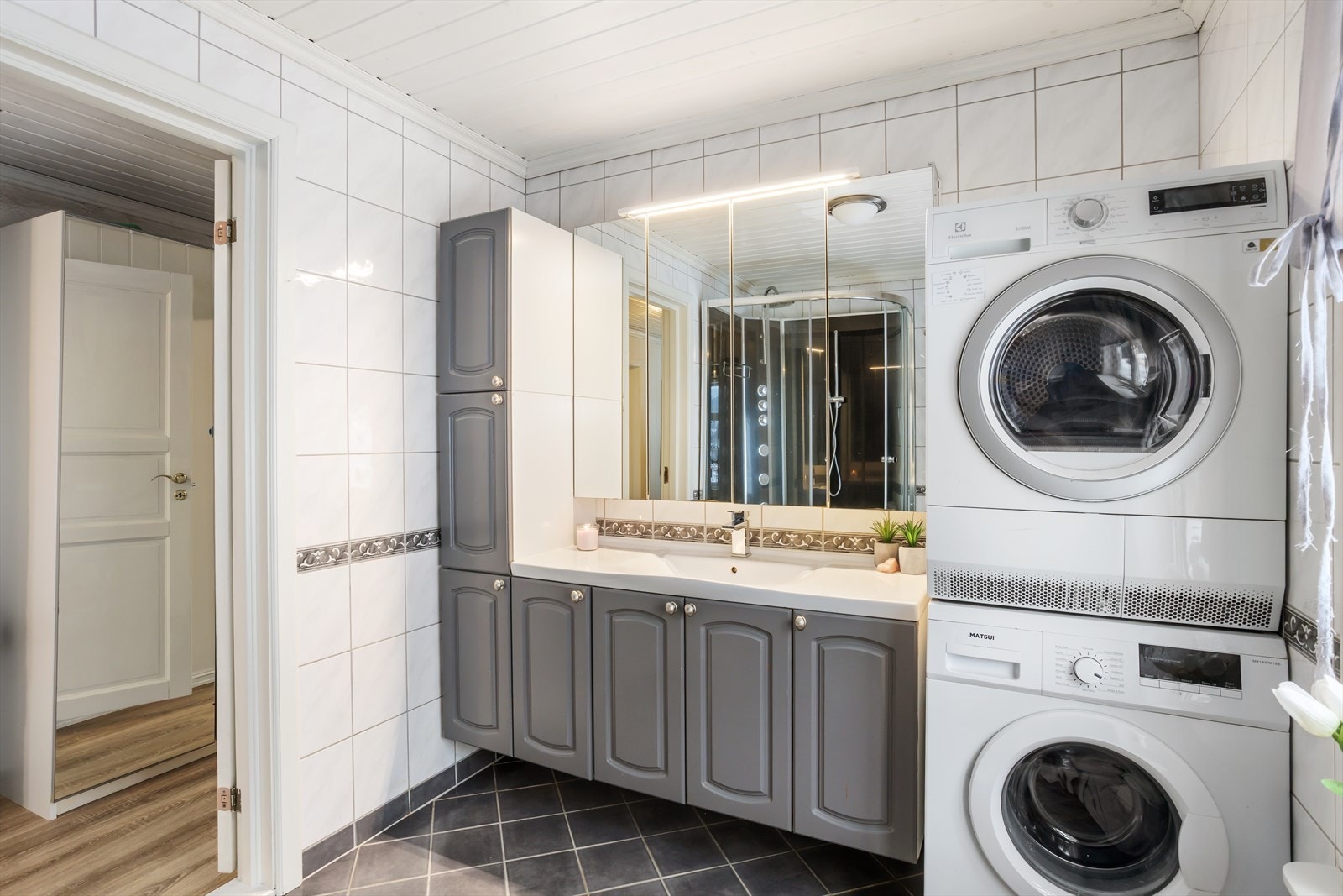 Tiltalende flislagt bade-/vaskerom i 2. etg. med profilert baderomsinnredning, servant, wc og opplegg for vaskemaskin/tørketrommel. Galleribilde