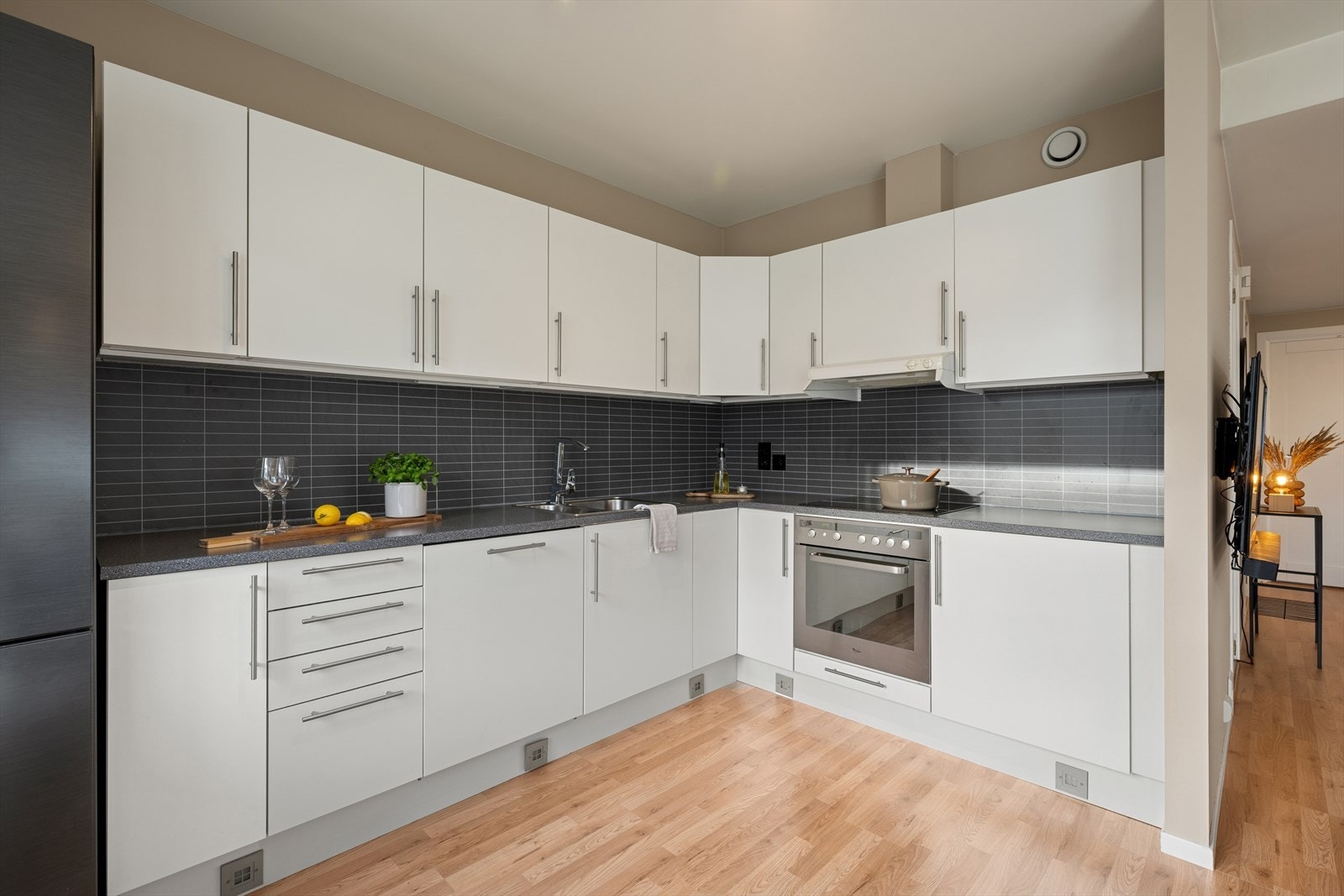 Kjøkkenet fra byggeår 2010 er i en åpen løsning med stuen og har en innredning med slette fronter og benkeplate i laminat. Galleribilde