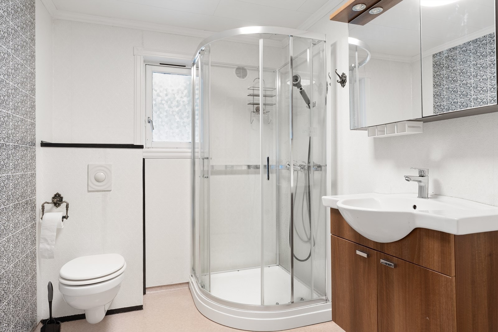 Pent bad med vegghengt toalett, dusjkabinet, speilskap og innredning med servant Galleribilde