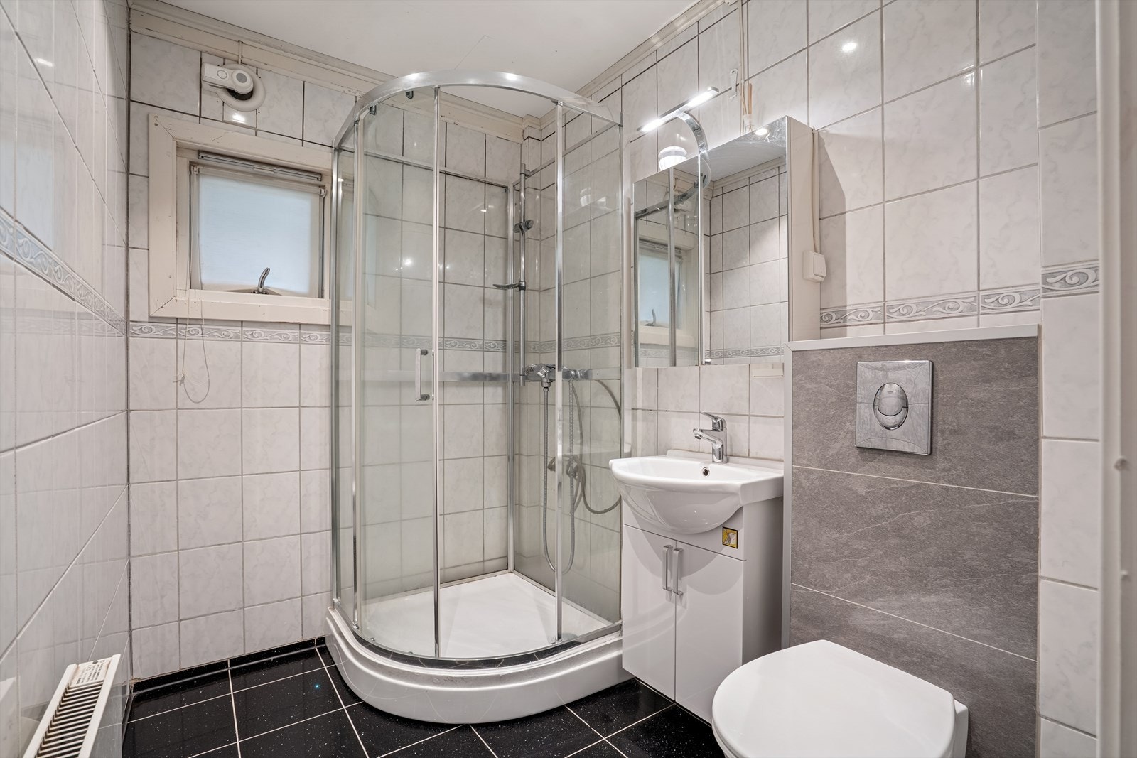 Pent flislagt bad/wc med flislagte overflater på vegg og gulv. Galleribilde