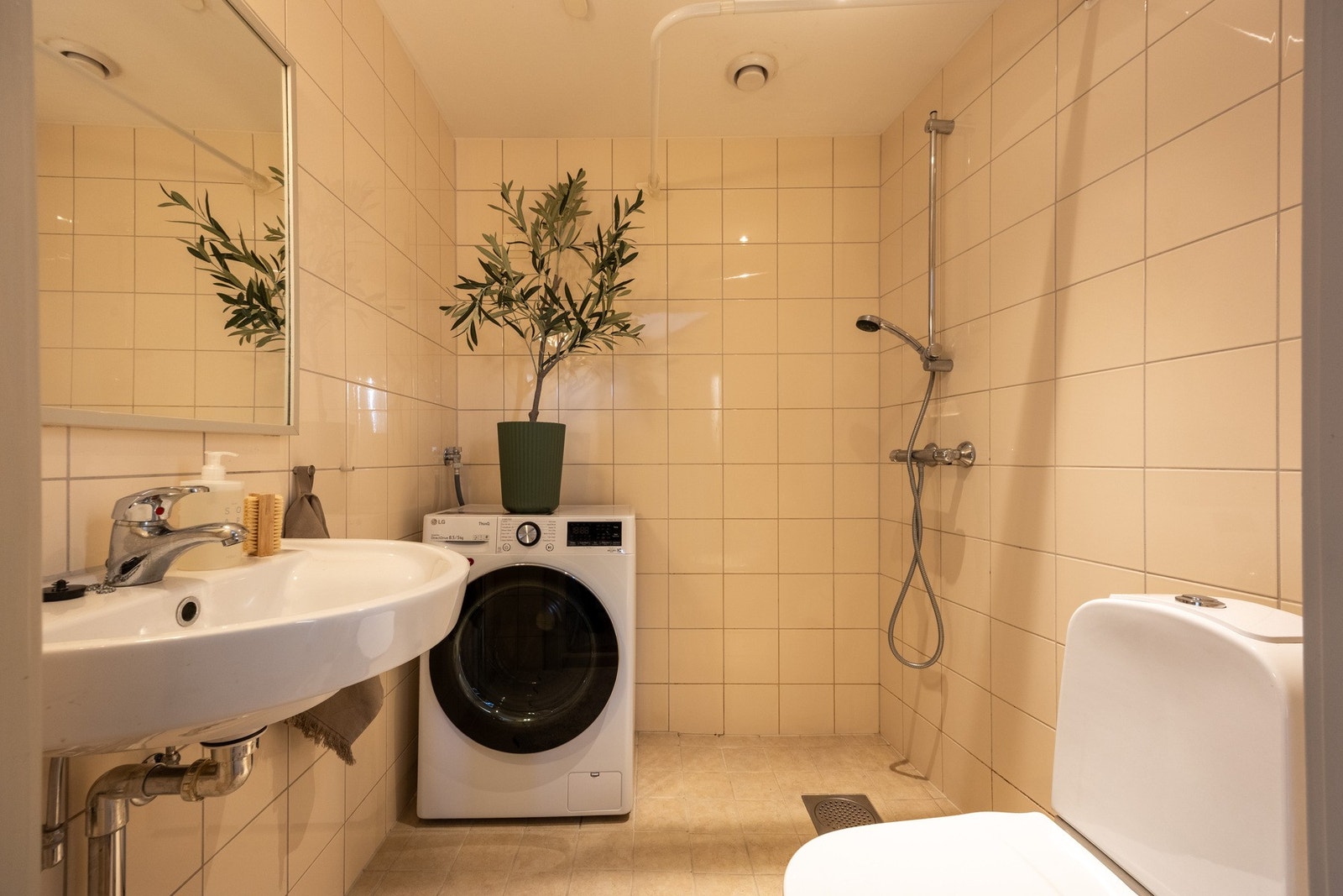 Romslig helfliset bad med opplegg for vaskemaskin. Galleribilde