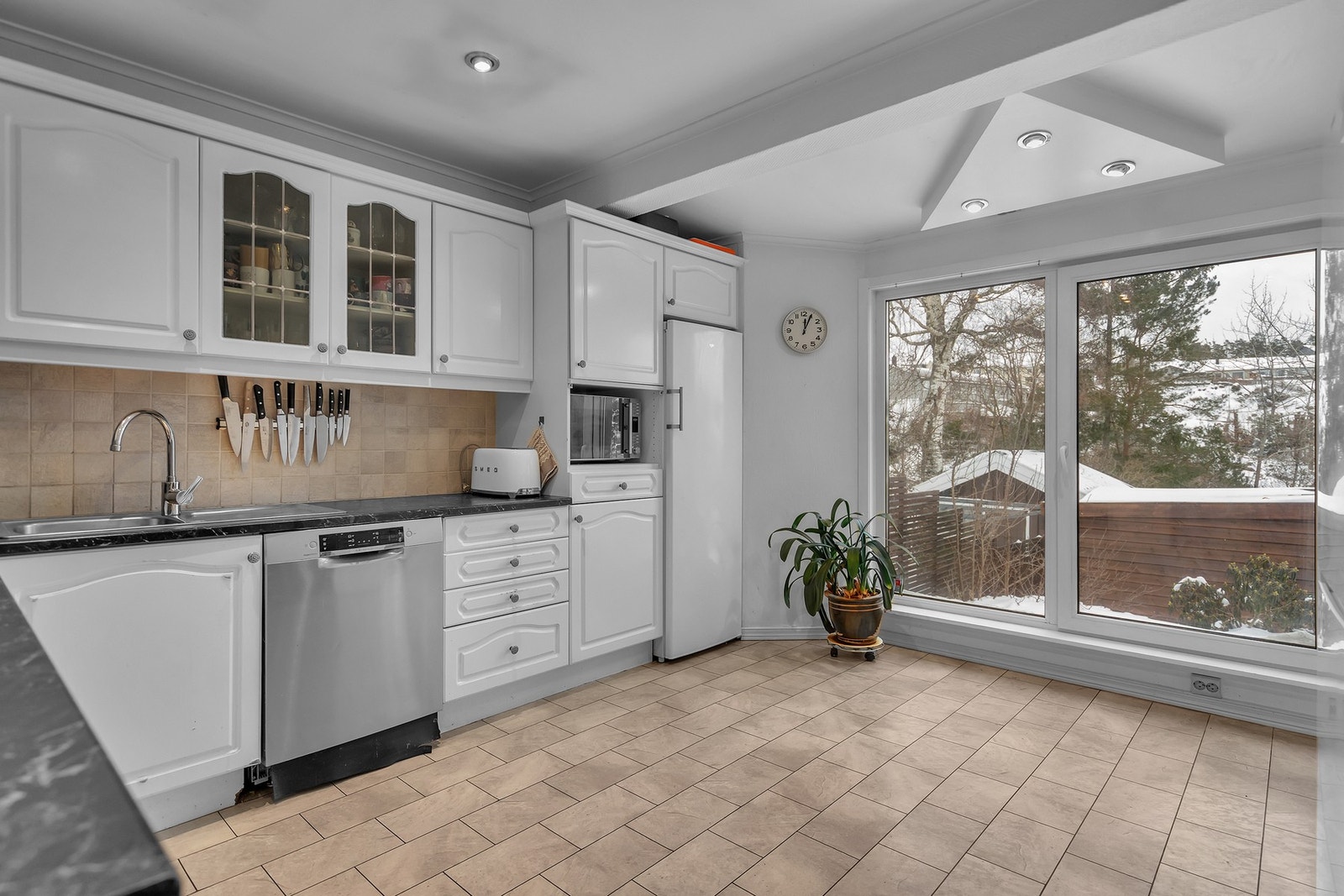 - Romslig kjøkken med fint lysinnslipp fra store vindusflater | Fungerende kjøkken med enkel standard - Galleribilde