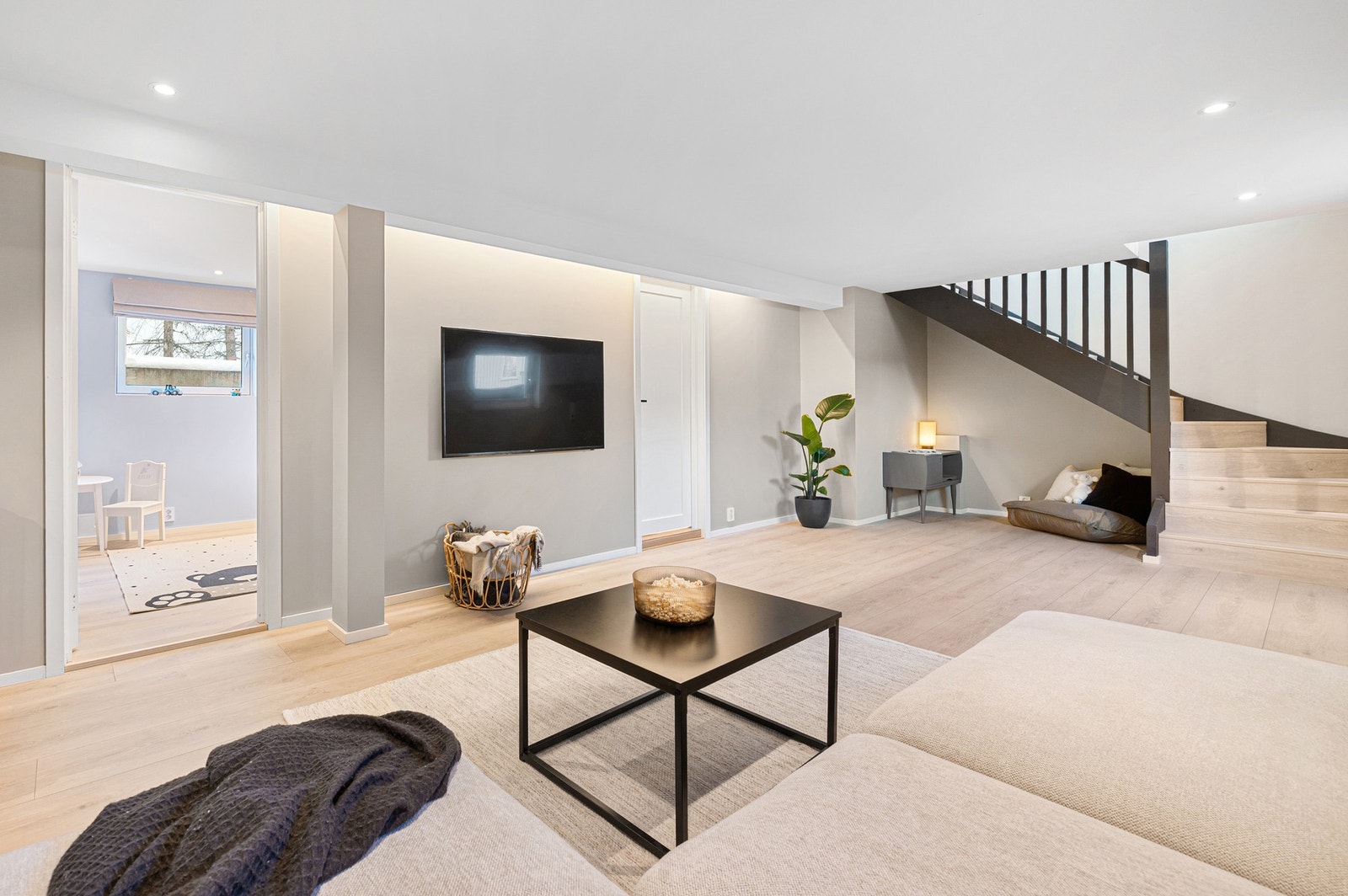 Delikat og innbydende kjellerstue med gjennomgående lyse overflater og moderne løsninger Galleribilde