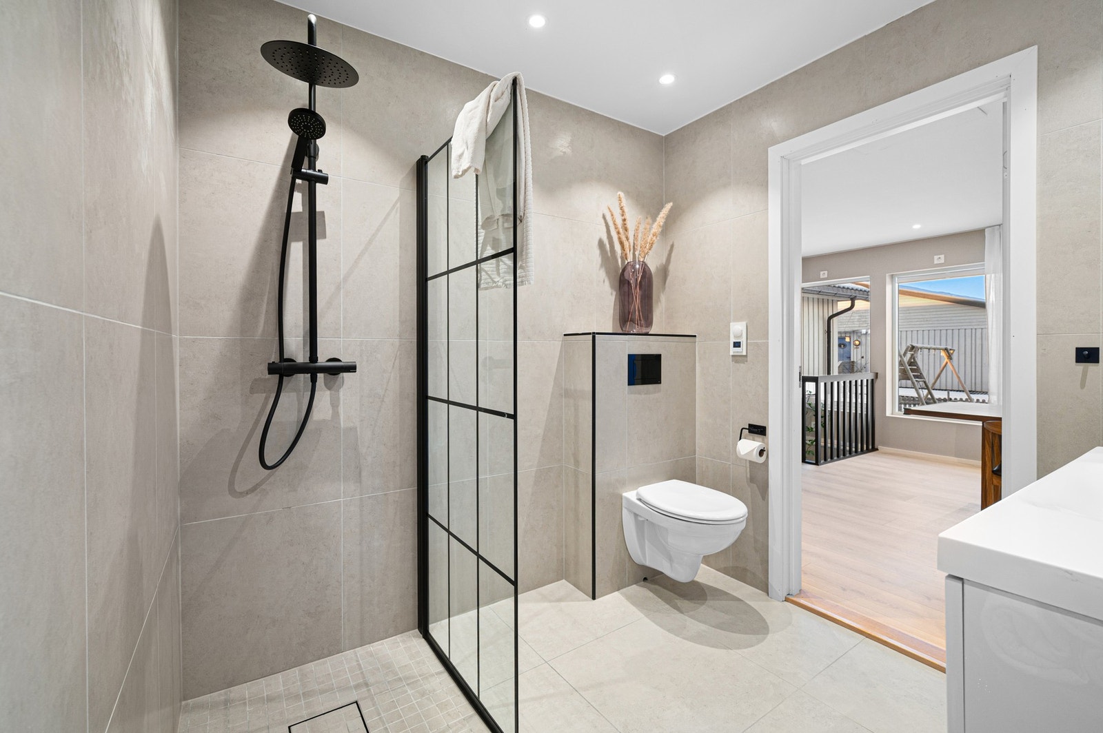 Lekkert flislagt baderom med elektriske varmekabler i 1. etasje. Galleribilde