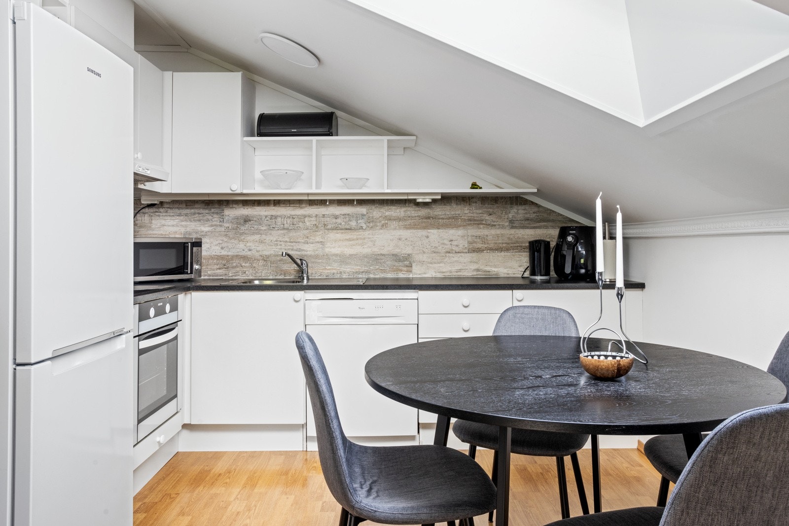 Kjøkkeninnredning med glatte fronter, fliser mellom kjøkkenbenk og overskap Galleribilde