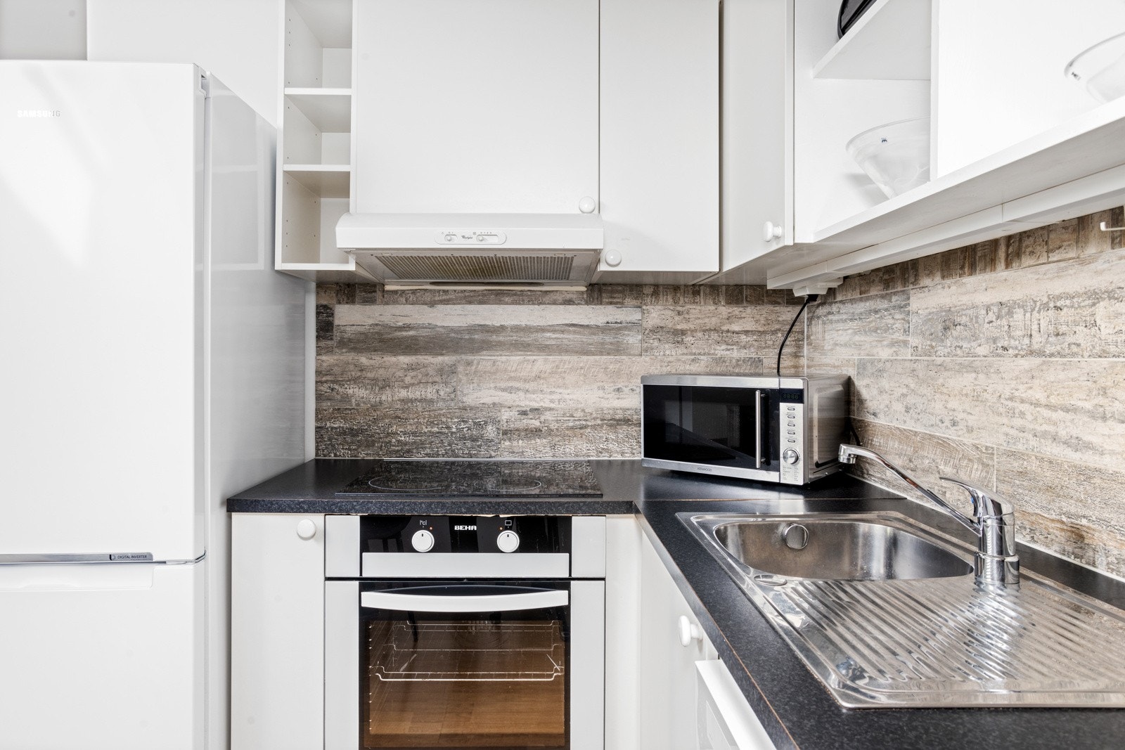 Kjøkken med integrert stekeovn og platetopp, oppvaskmaskin under kjøkkenbenk Galleribilde