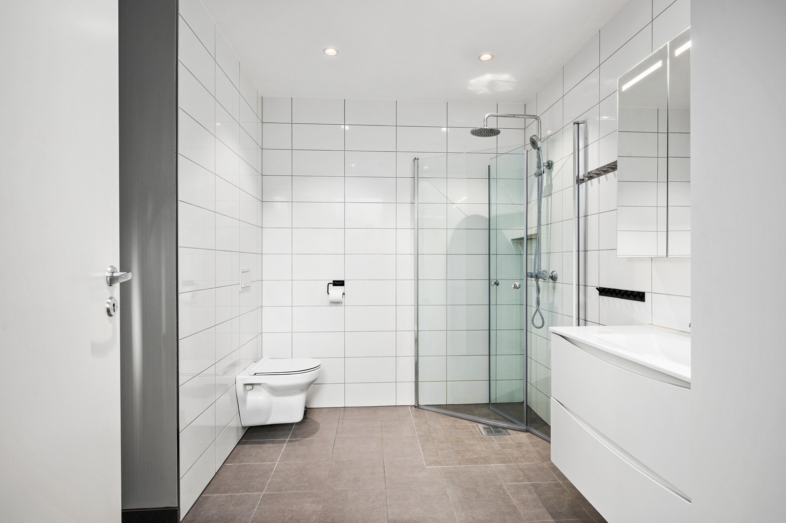 Baderommet i 1.etasje er et kombinert vaskerom og bad, med egen praktisk inngang. Galleribilde