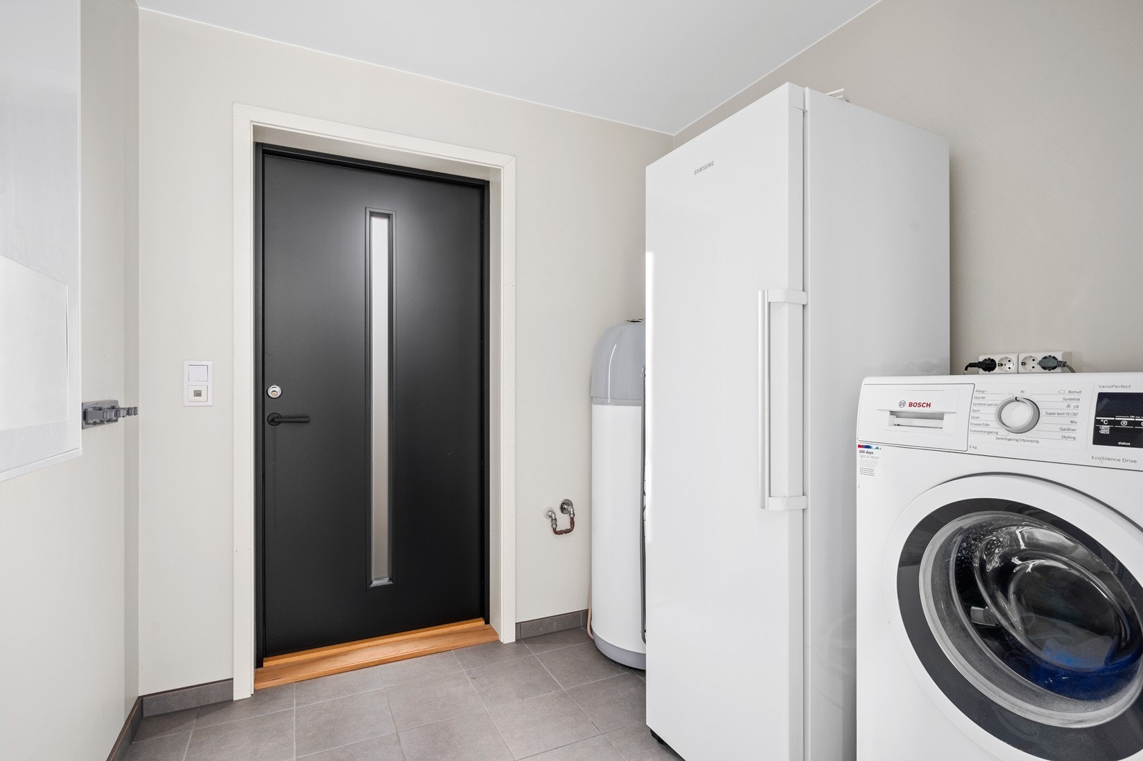 Et praktisk kombi-rom med muligheter for å vaske tøy og god plass til oppbevaring av annet diverse. Galleribilde