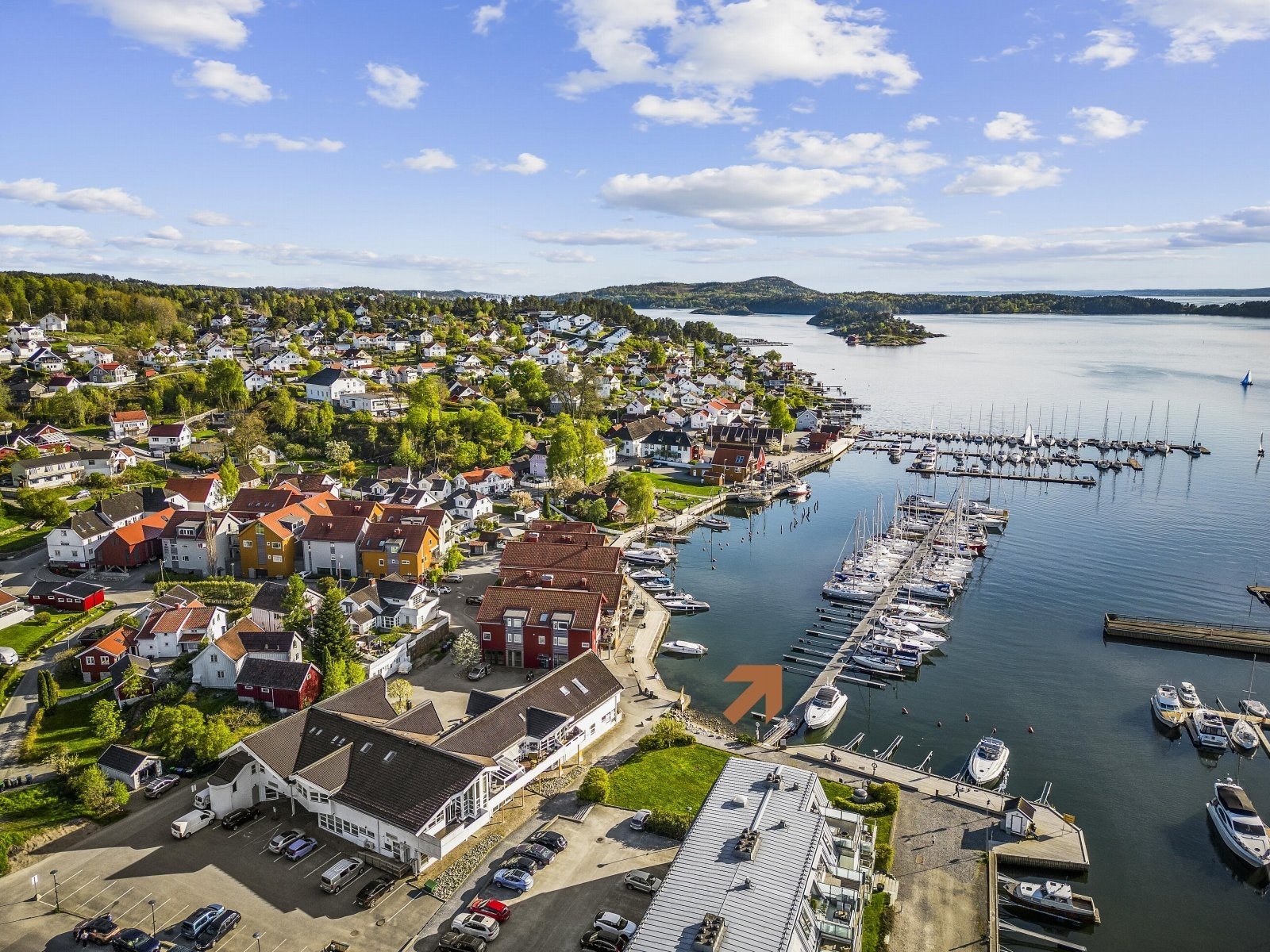 Leiligheten disponerer 2 parkeringskort som gir gratis parkering på nordsiden av bygningen. Pil viser båtplass. Galleribilde