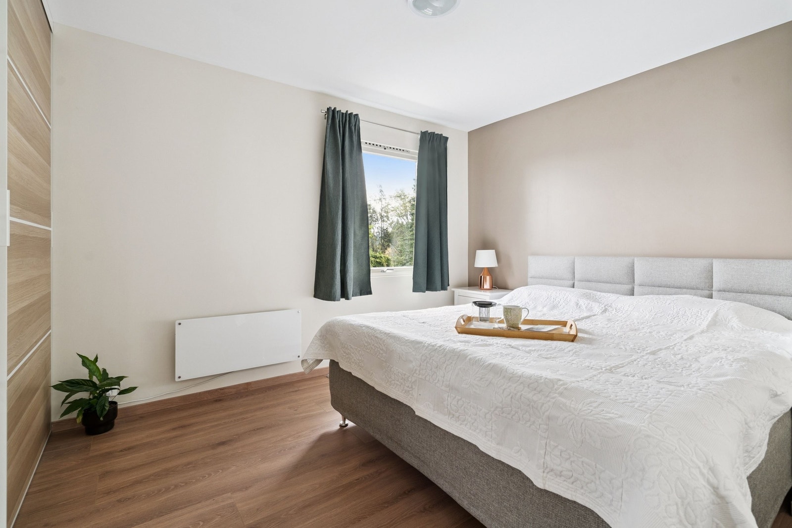 Lyst og komfortabelt hovedsoverom Galleribilde