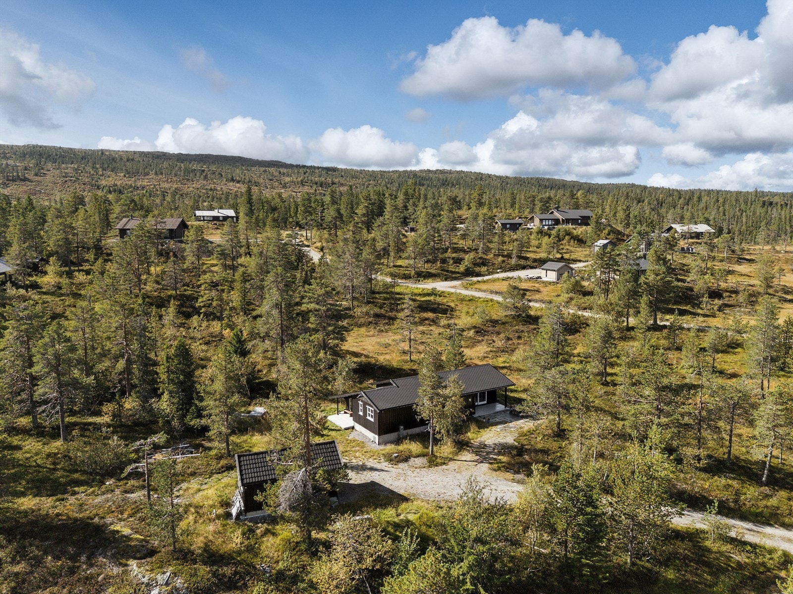 Badstuen har egen uteplass mellom byggene, en lun og praktisk sone som gir deilige pauser i frisk luft og gjør hyttelivet enda mer komfortabelt. Garasjen ble oppført 2014. Galleribilde