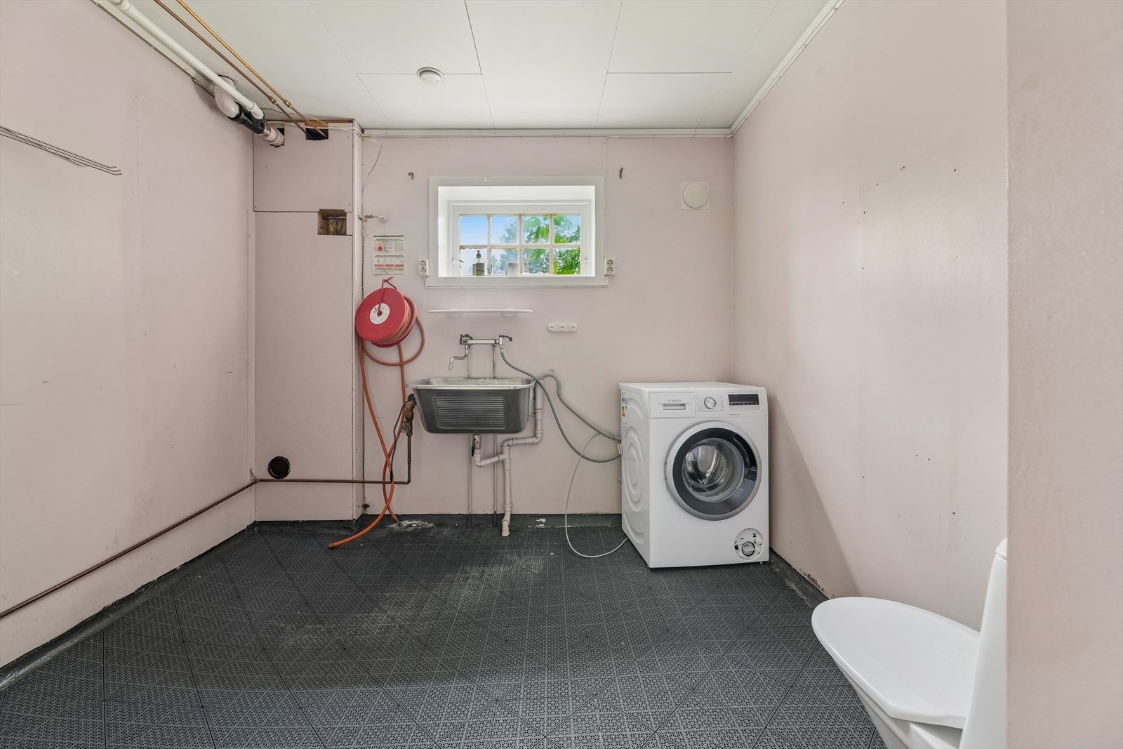Rommet har gulvbelegg og vegger av malte plater, og er utstyrt med toalett, utslagsvask og opplegg for vaskemaskin. Rommet har en praktisk størrelse samtidig som det byr på gode muligheter for oppgradering og tilpasning etter egne ønsker. Galleribilde
