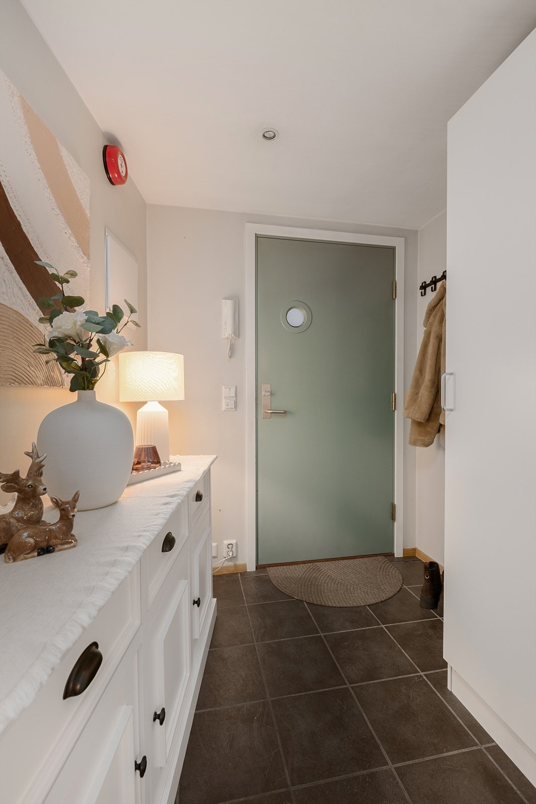 Entréen har flislagt gulv med gulvvarme, som gir en behagelig velkomst. Galleribilde