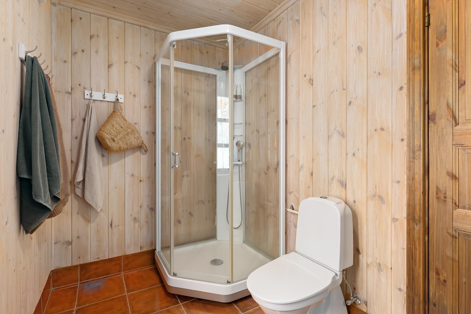 Badet er utstyrt med dusjkabinett og toalett - det er også flislagt gulv med varmekabler. Galleribilde