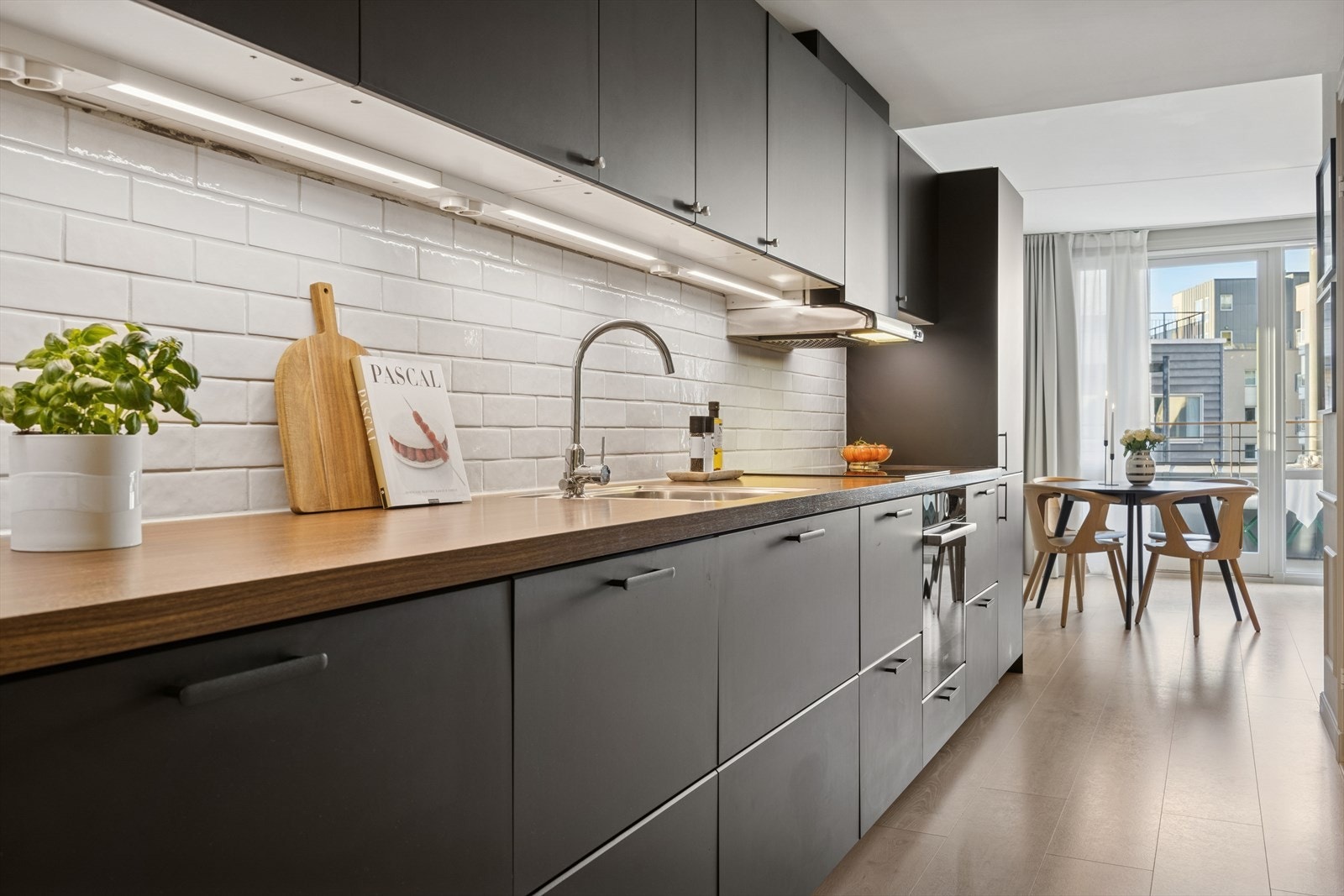 Stilren kjøkkeninnredning med folierte skrog med slette fronter og laminert benkeplate. Galleribilde