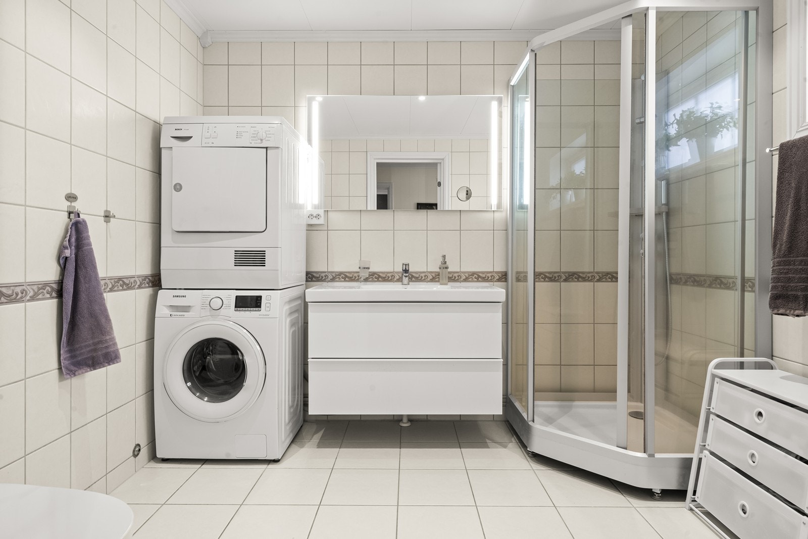 Flislagt bad med dusj, servant på skap og wc. Galleribilde