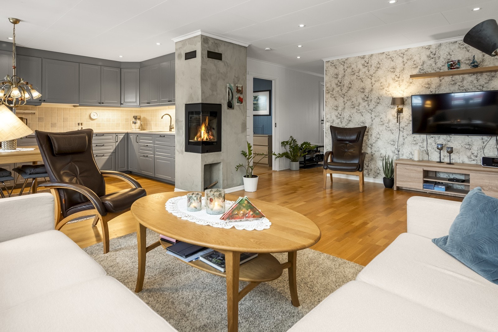 Nyere peisovn plassert midt i rommet som gir god varme på den kalde årstiden Galleribilde