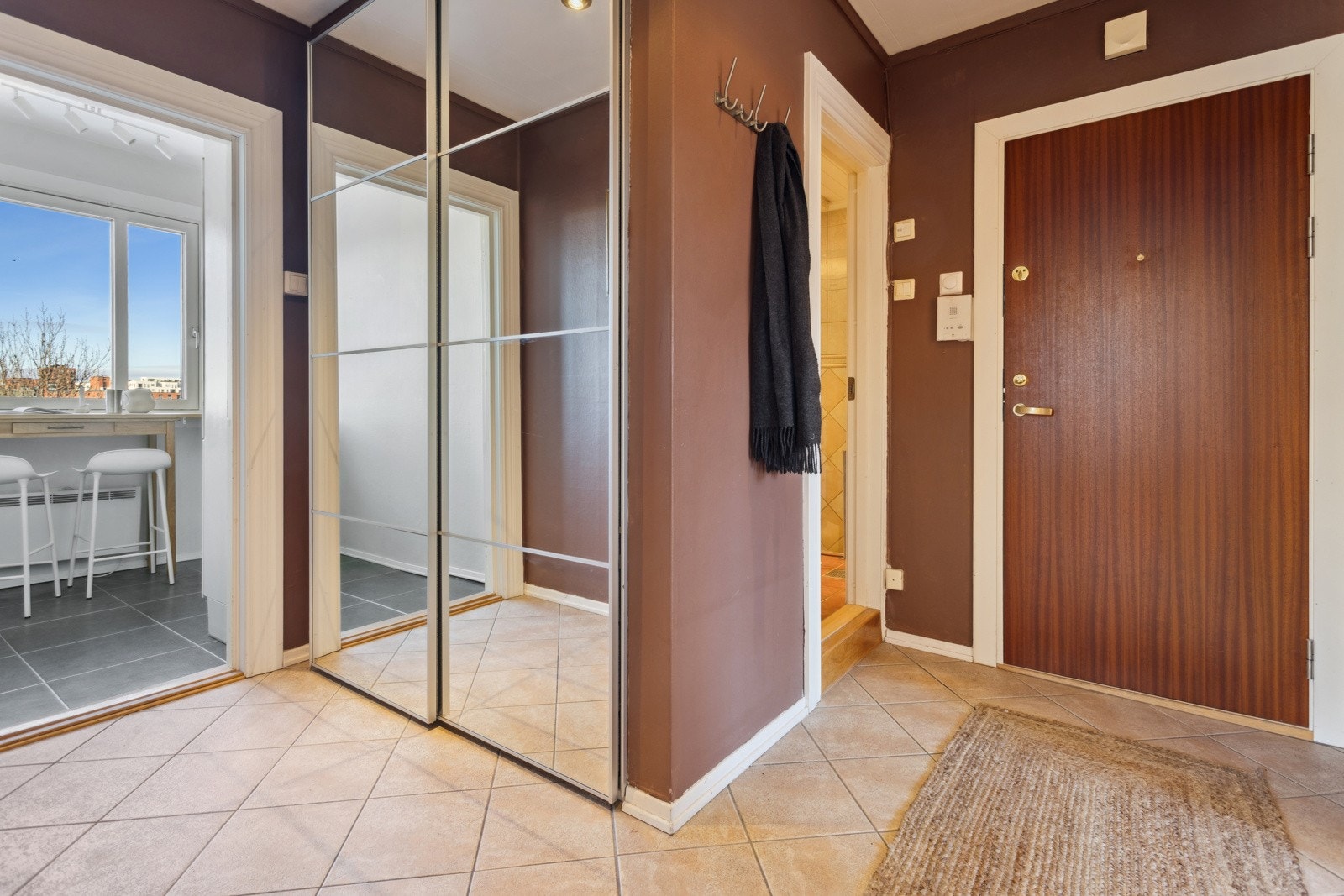 Fra flislagt entré med praktisk skyvedørsgarderobe Galleribilde