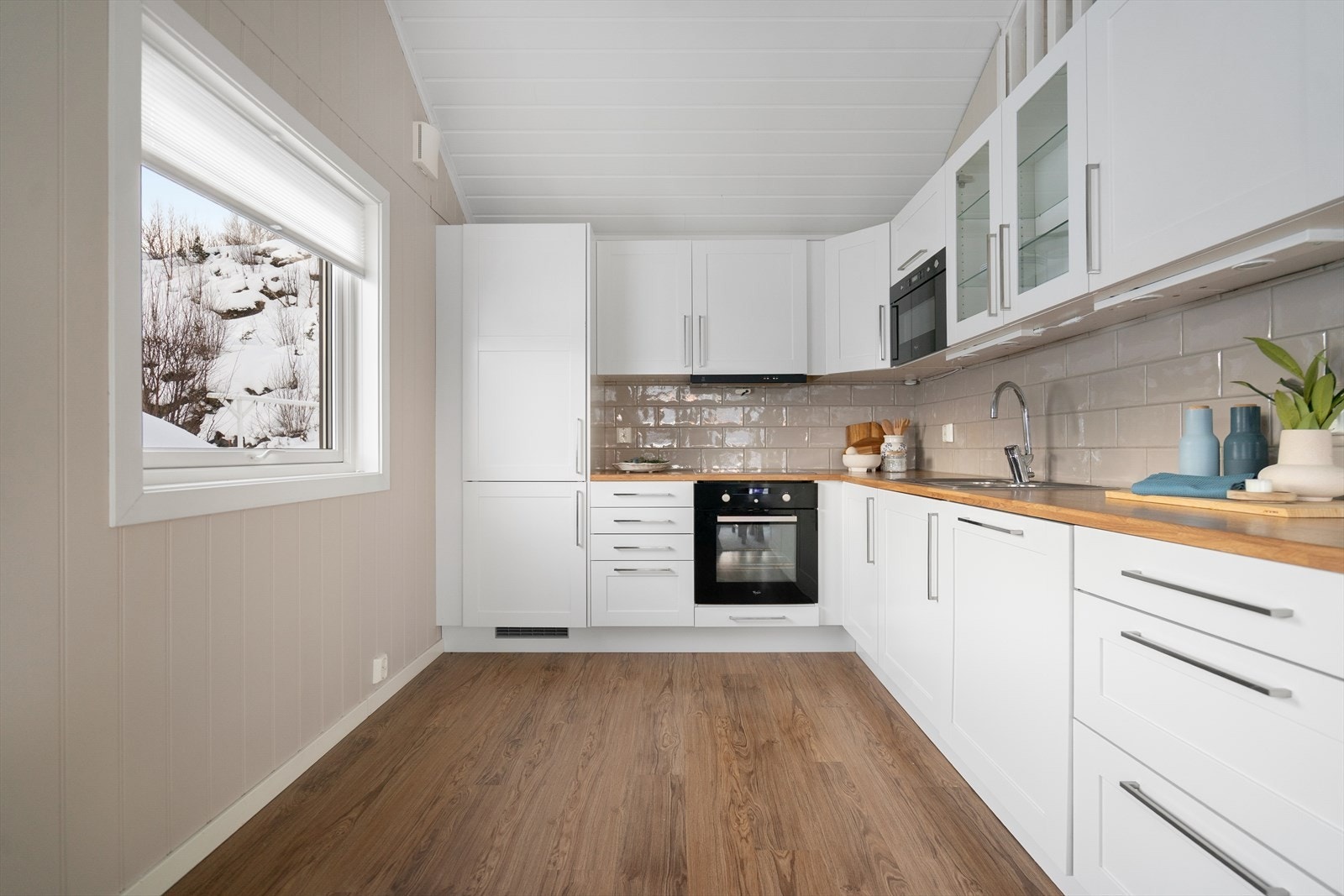 Kjøkkenet har lyse profilerte fronter og benkeplate av laminat. Galleribilde