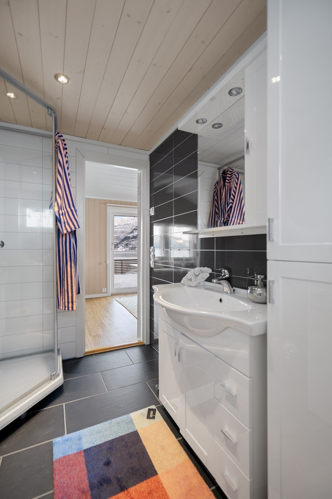 Det er flislagt gulv med varmekabler på badet. Galleribilde