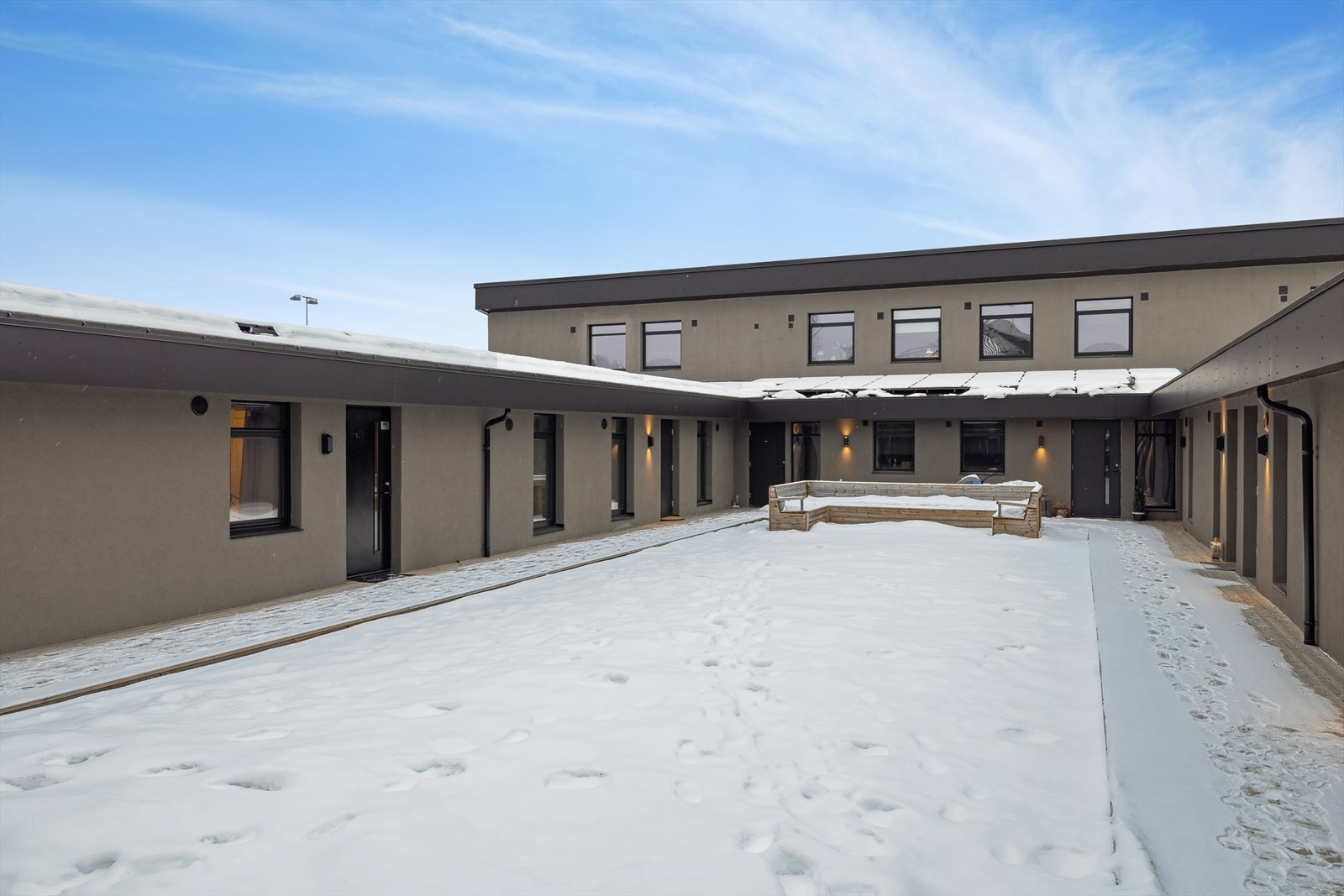 Lettstelt felles tomt med sittebenker og grøntareal med kunstgress. Galleribilde