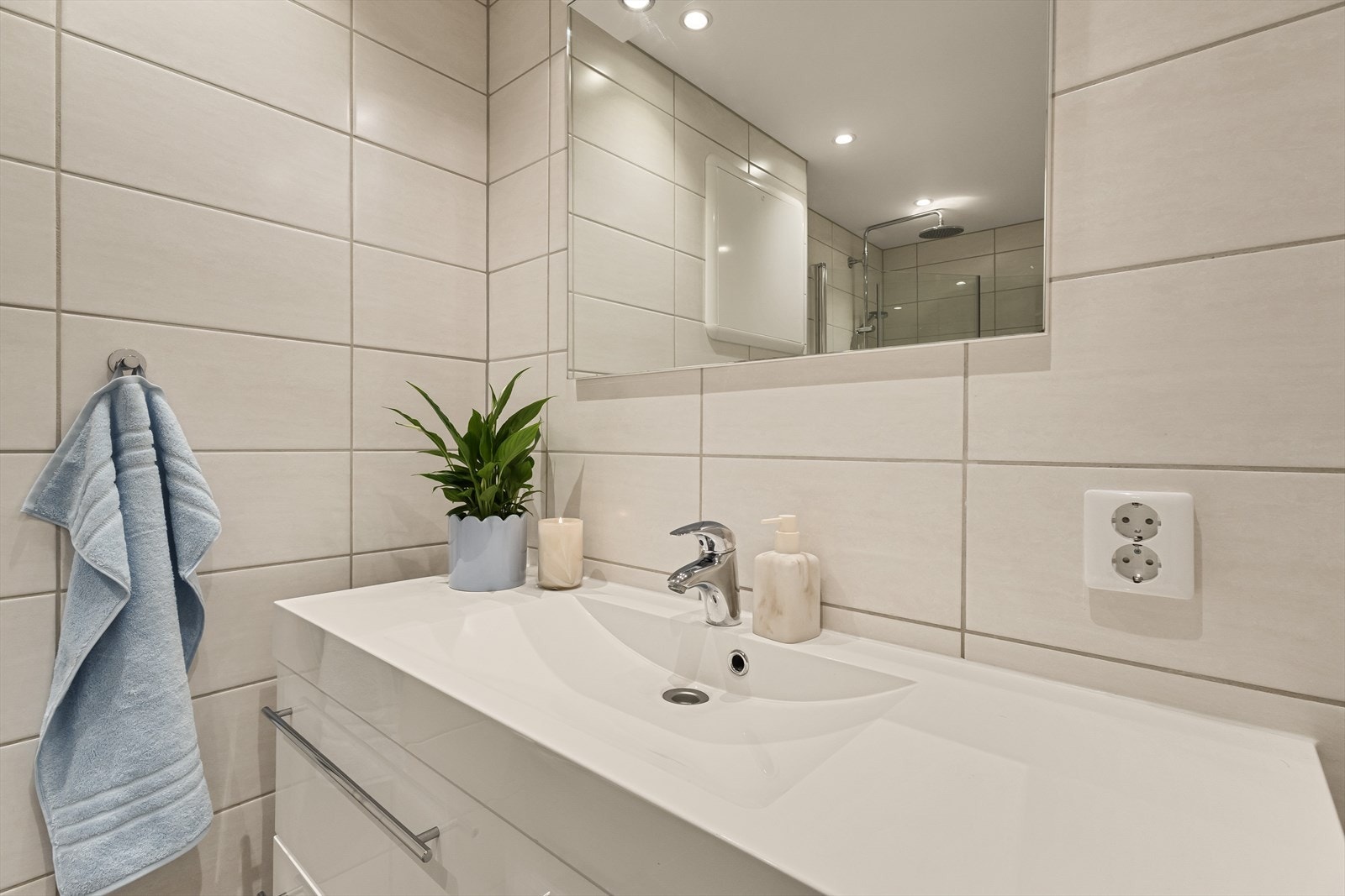 Baderommet har keramiske fliser på gulv og vegger, og malt platekledning samt innfelte spotlights i taket Galleribilde