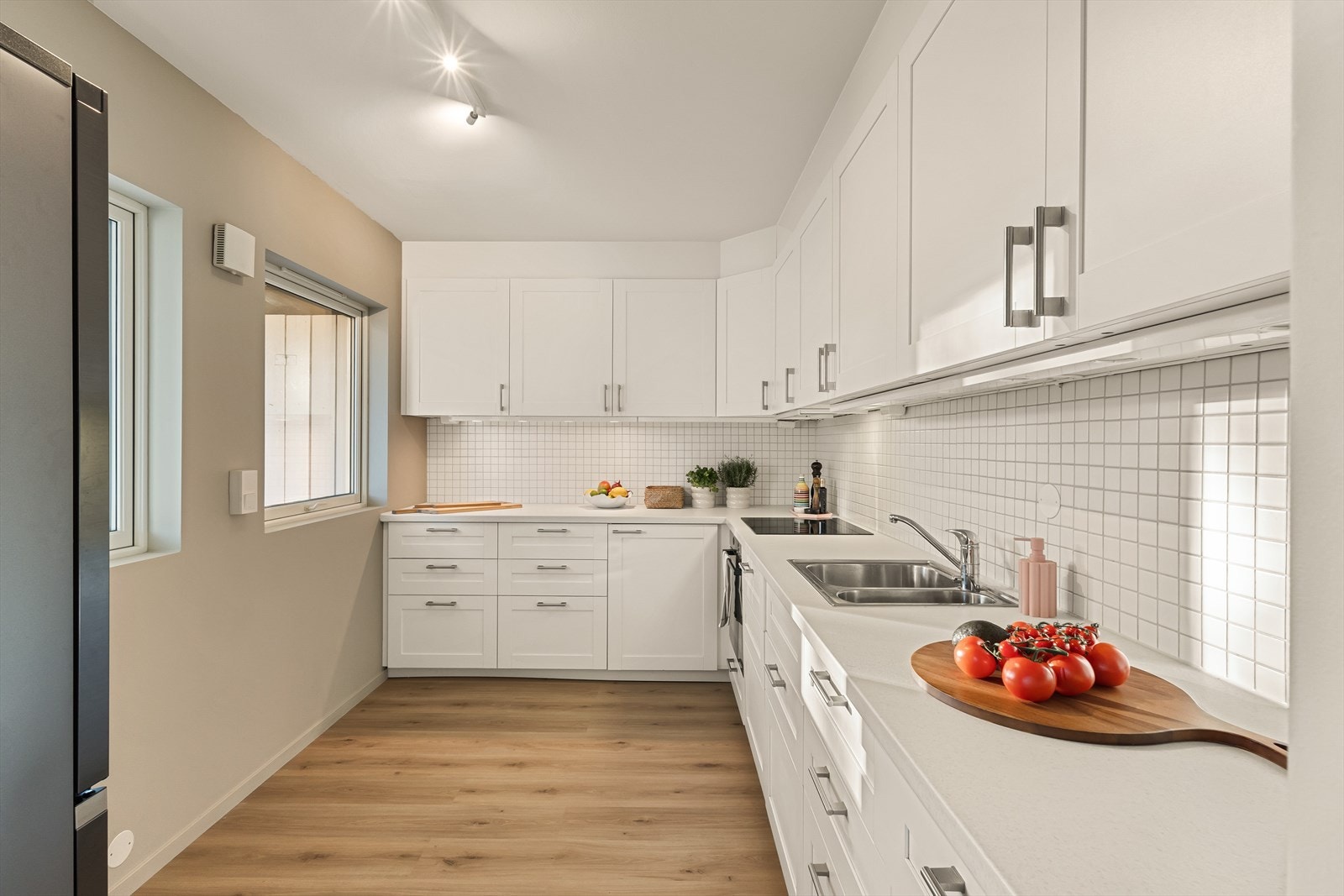 Flott kjøkken fra IKEA med profilerte fronter, laminert benkeplate, vaskekum i stål, ventilator og opplegg for oppvaskmaskin Galleribilde